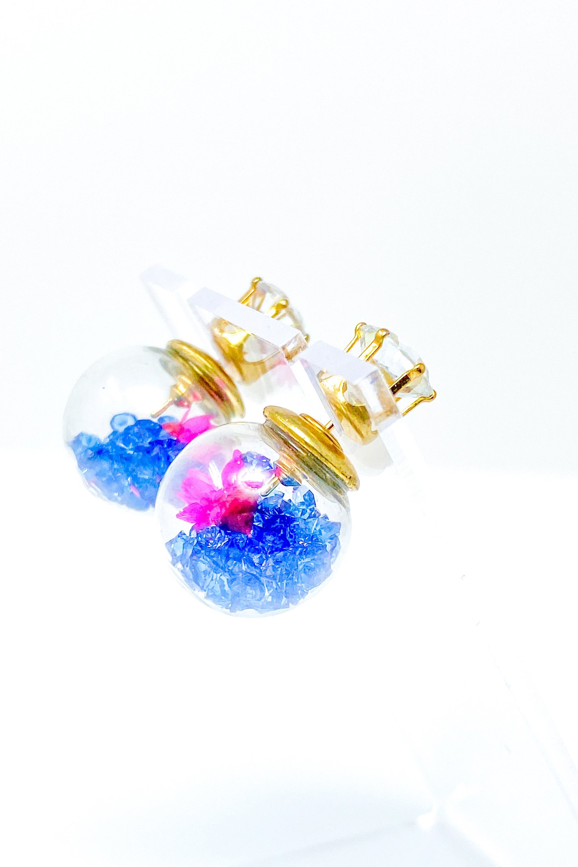 Perennial Ice Studs featuring handcrafted moving flowers and a plastique ice ball design in gold and multicolored options.