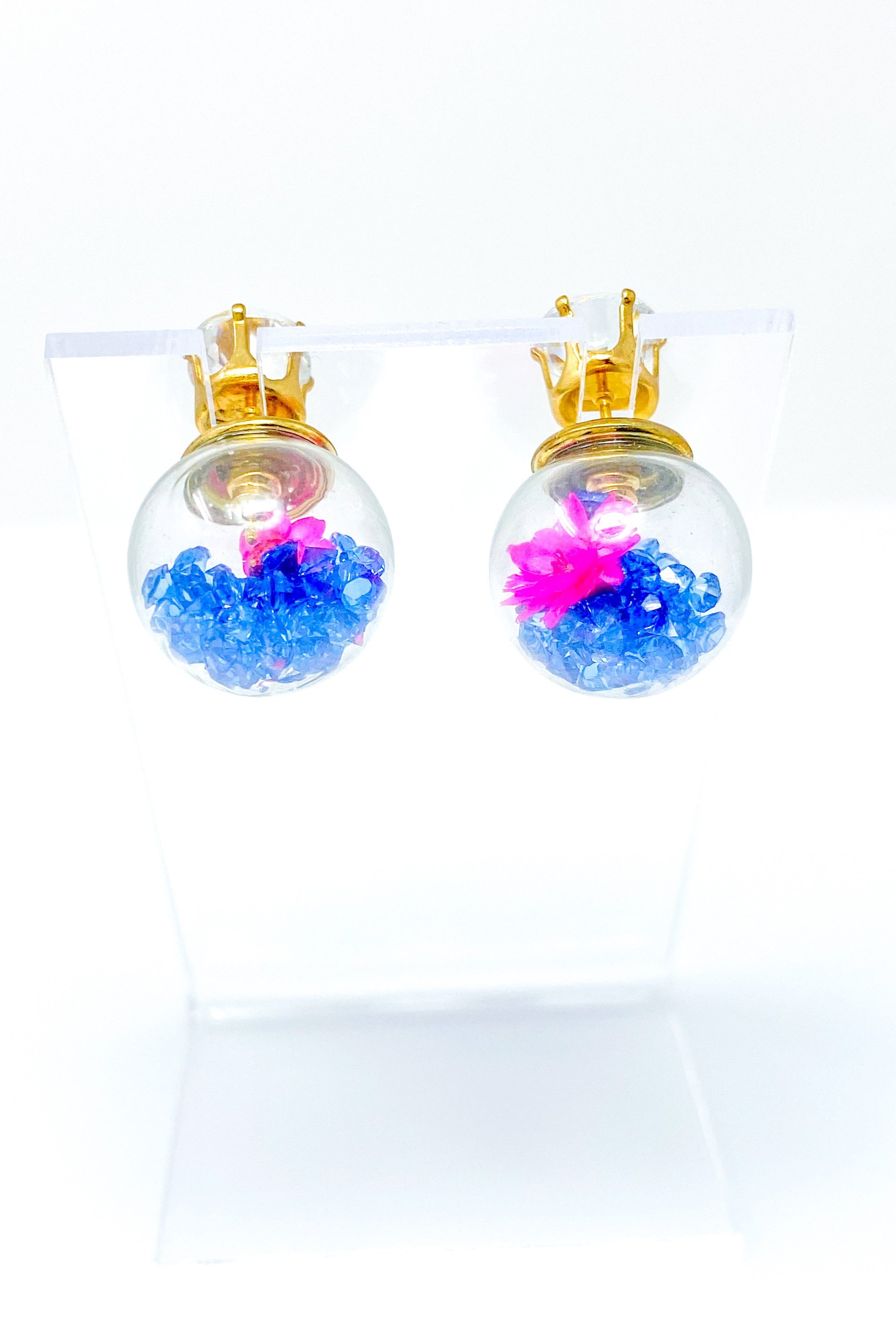 Perennial Ice Studs featuring handcrafted moving flowers and a plastique ice ball design in gold and multicolored options.