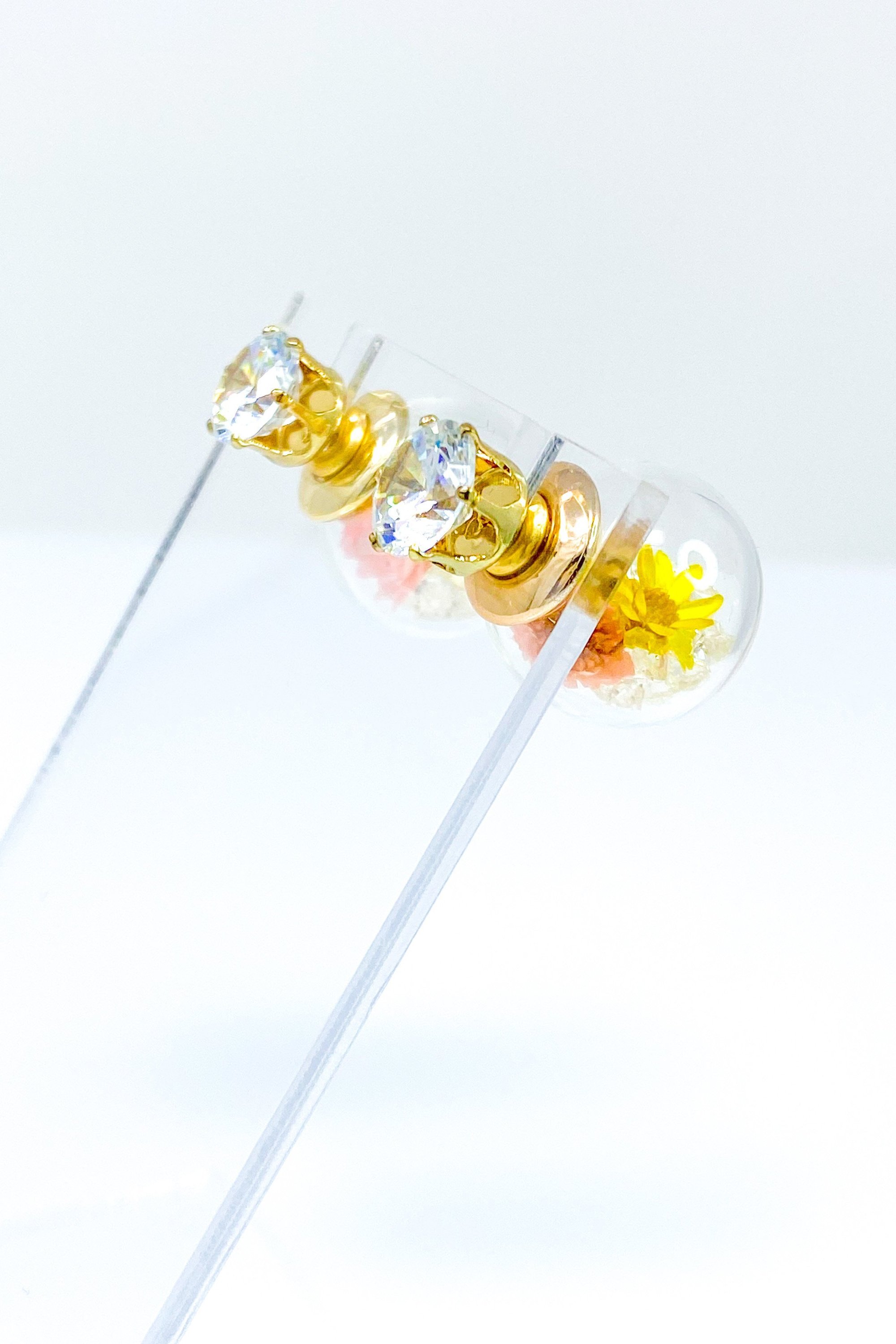 Perennial Ice Studs featuring handcrafted moving flowers and a plastique ice ball design in gold and multicolored options.