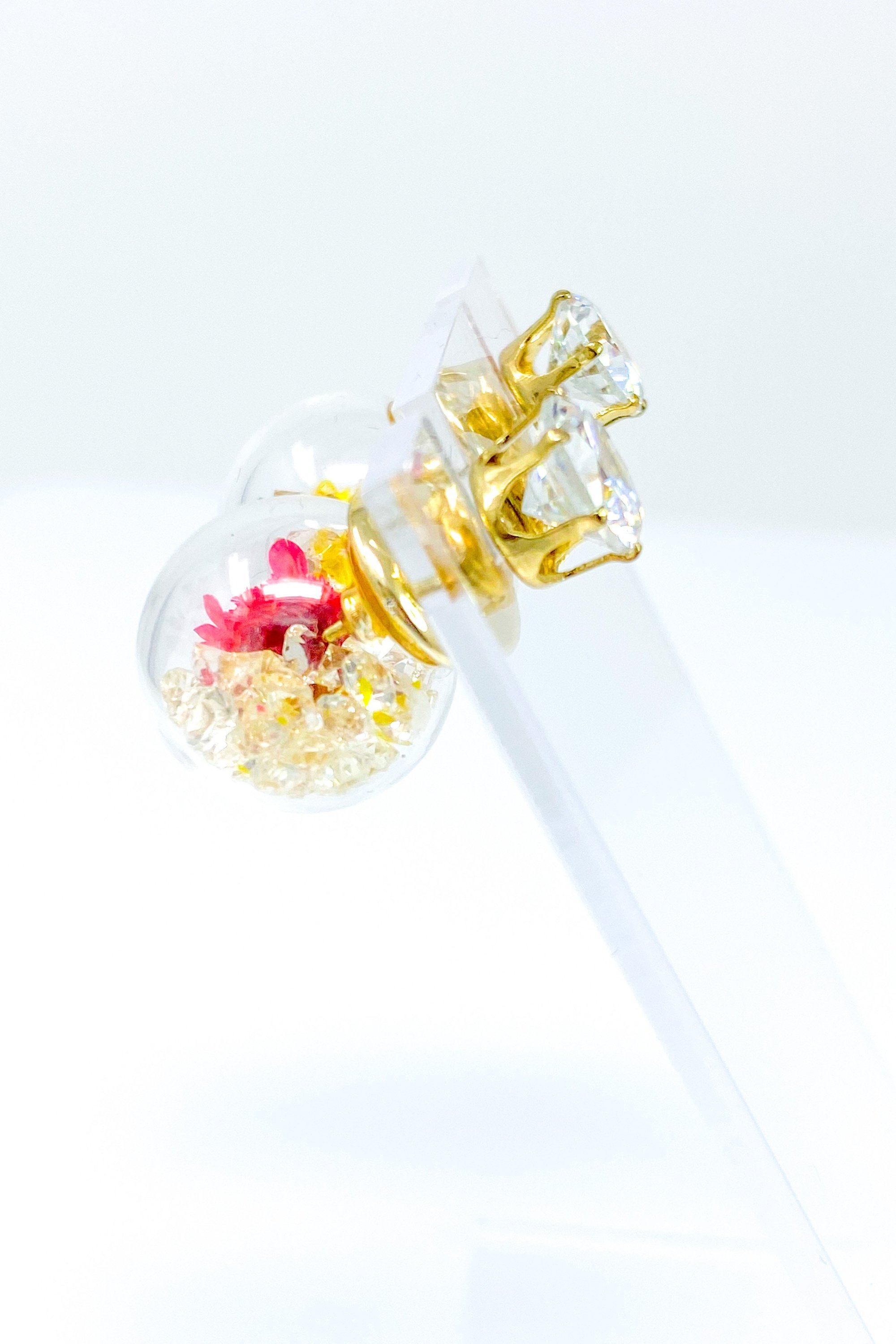 Perennial Ice Studs featuring handcrafted moving flowers and a plastique ice ball design in gold and multicolored options.