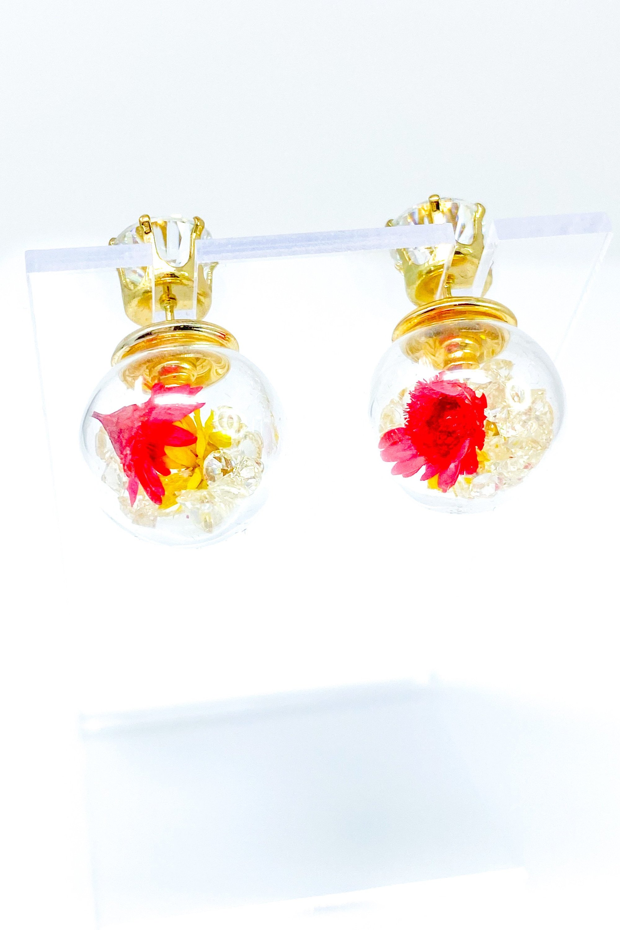 Perennial Ice Studs featuring handcrafted moving flowers and a plastique ice ball design in gold and multicolored options.