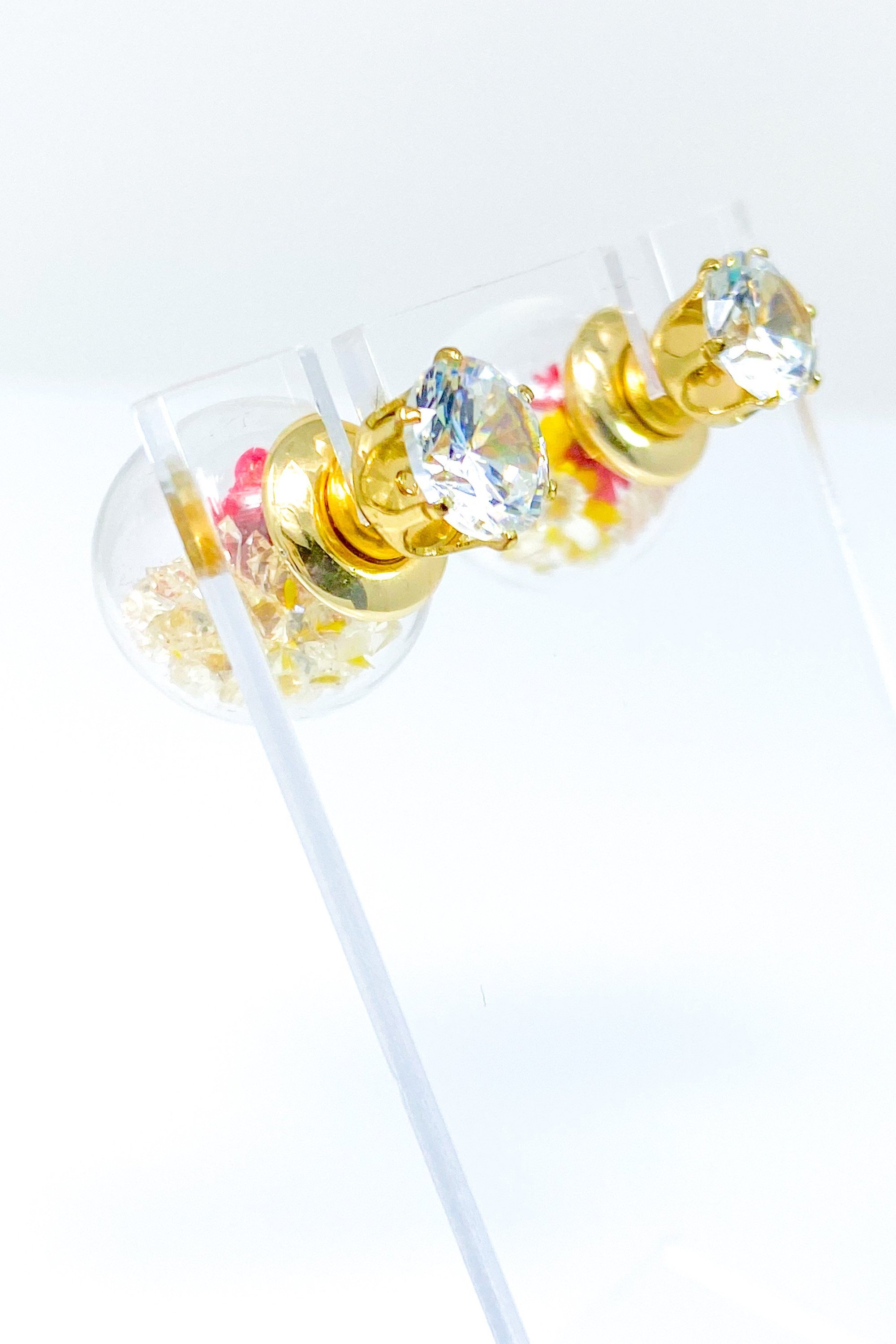 Perennial Ice Studs featuring handcrafted moving flowers and a plastique ice ball design in gold and multicolored options.