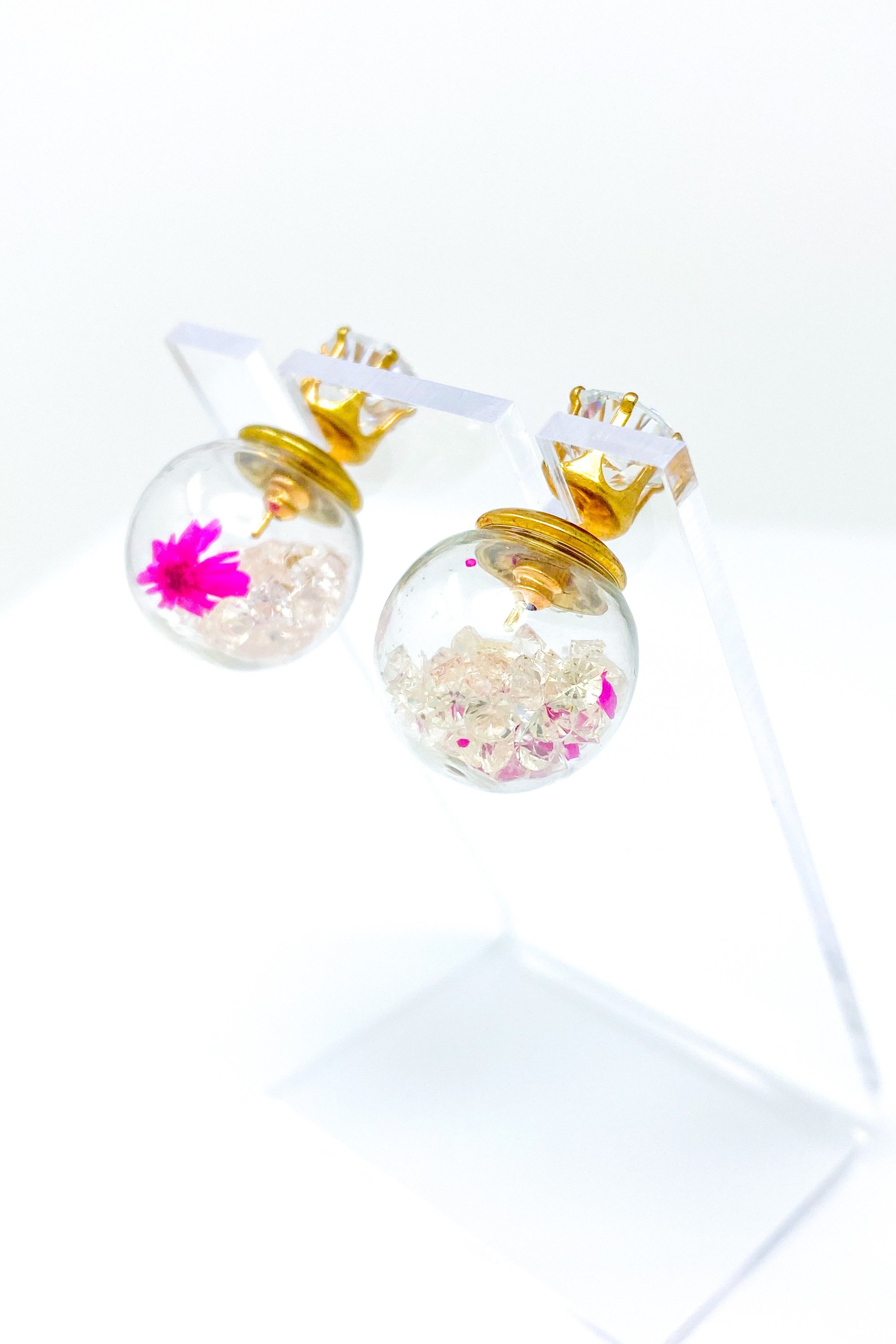 Perennial Ice Studs featuring handcrafted moving flowers and a plastique ice ball design in gold and multicolored options.