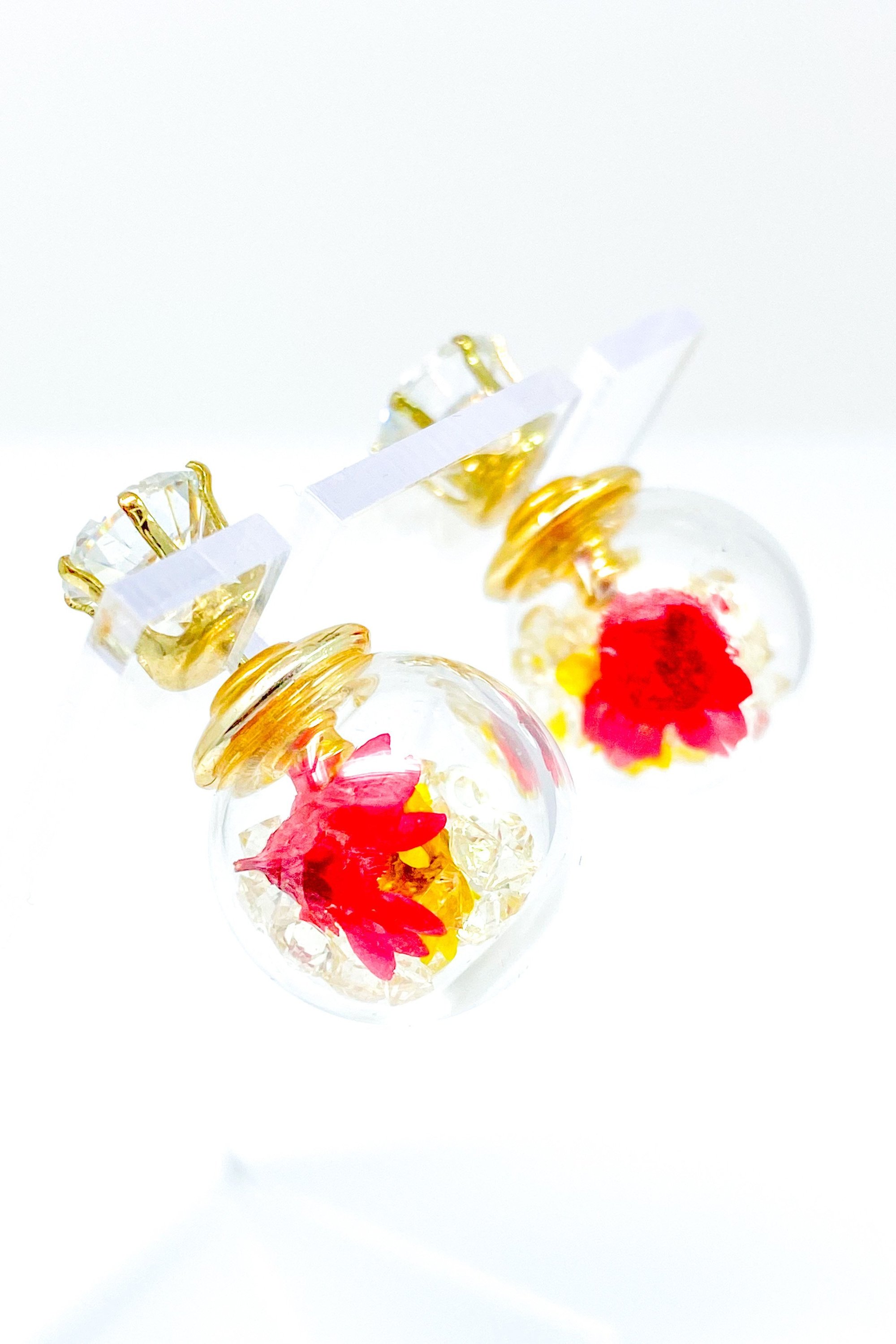 Perennial Ice Studs featuring handcrafted moving flowers and a plastique ice ball design in gold and multicolored options.