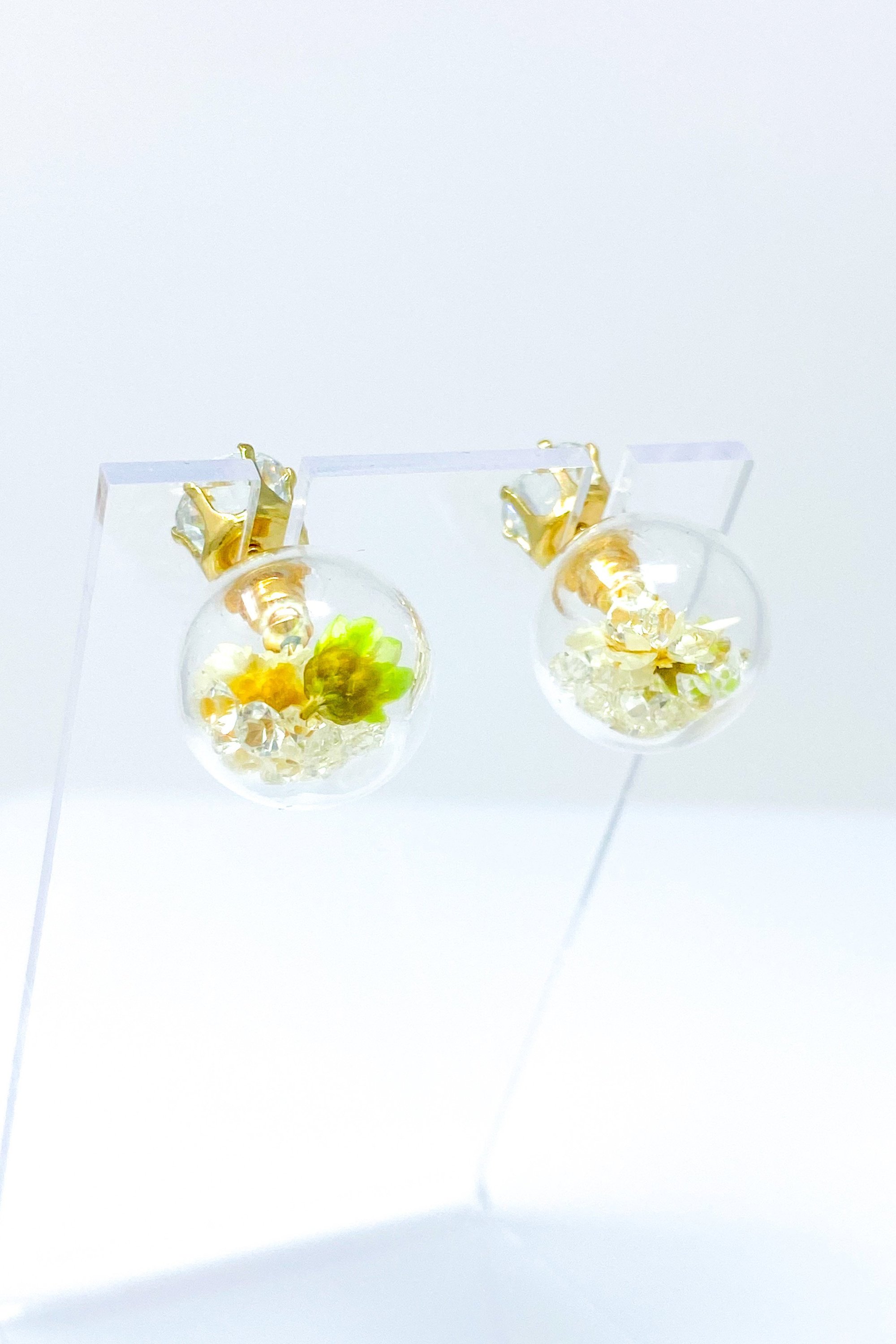 Perennial Ice Studs featuring handcrafted moving flowers and a plastique ice ball design in gold and multicolored options.