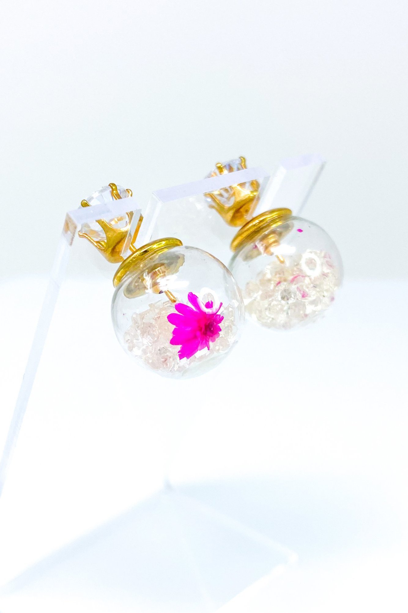 Perennial Ice Studs featuring handcrafted moving flowers and a plastique ice ball design in gold and multicolored options.