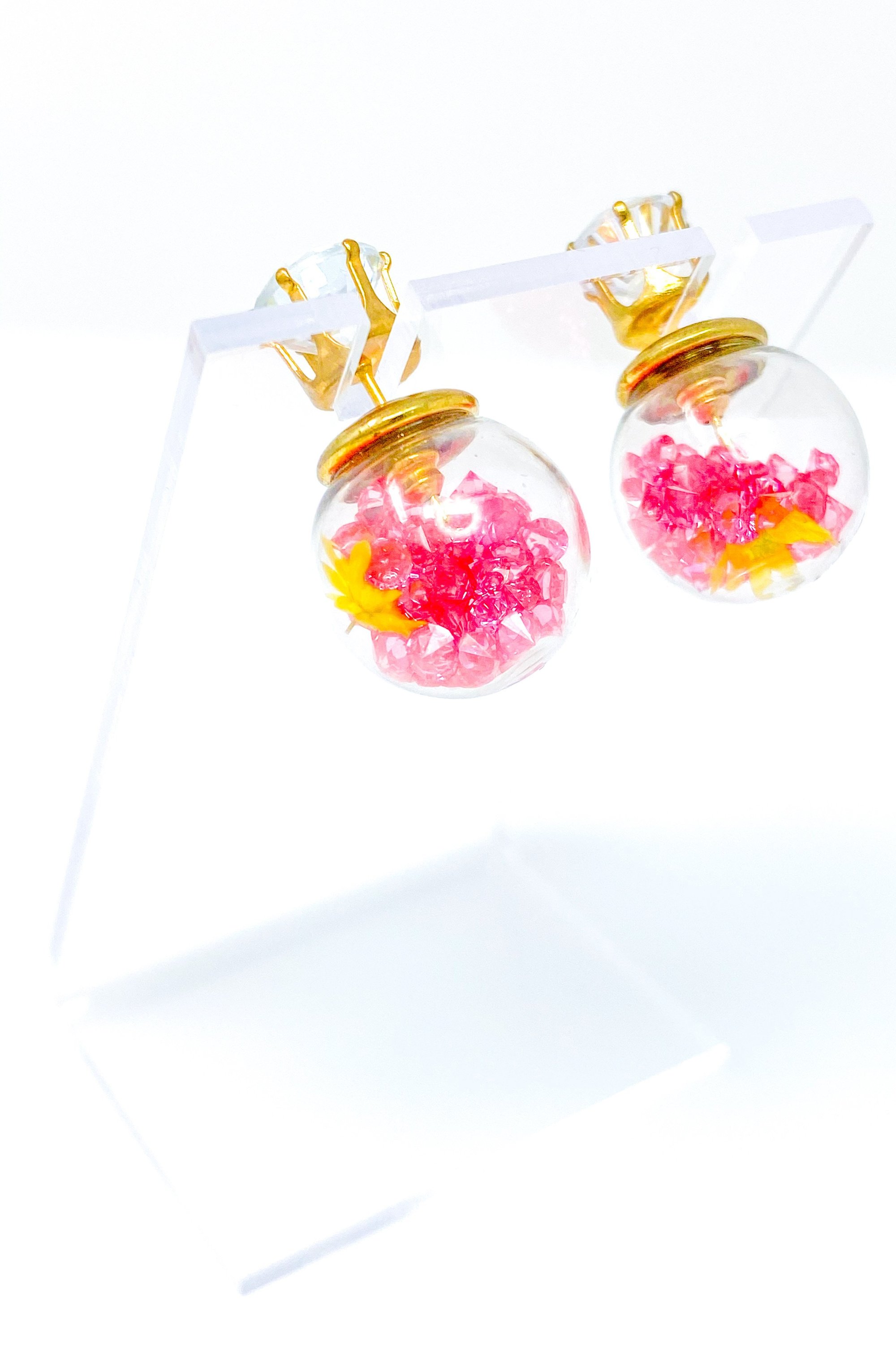 Perennial Ice Studs featuring handcrafted moving flowers and a plastique ice ball design in gold and multicolored options.