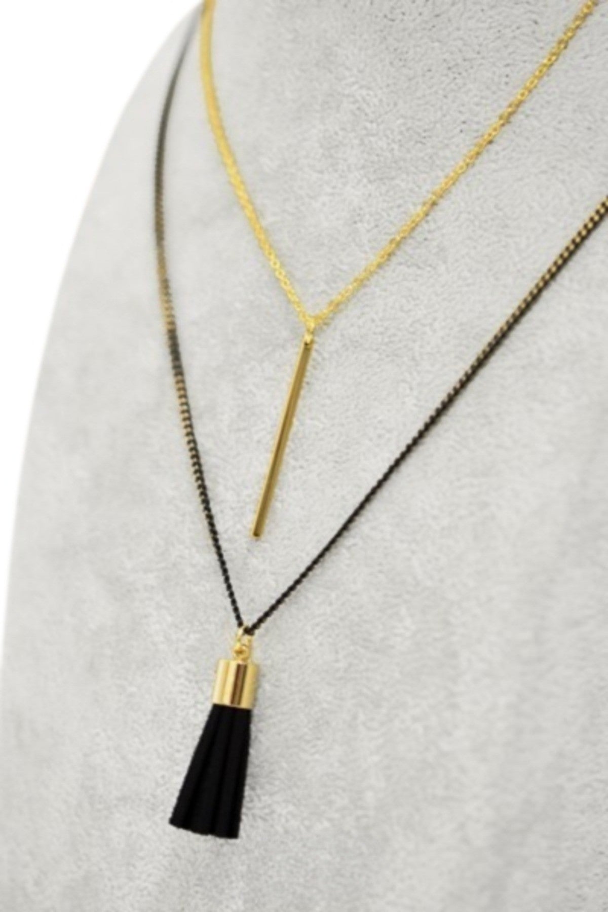 A stylish two-chain layered necklace featuring a metallic bar and a black cord tassel, showcasing a gold and black coating.