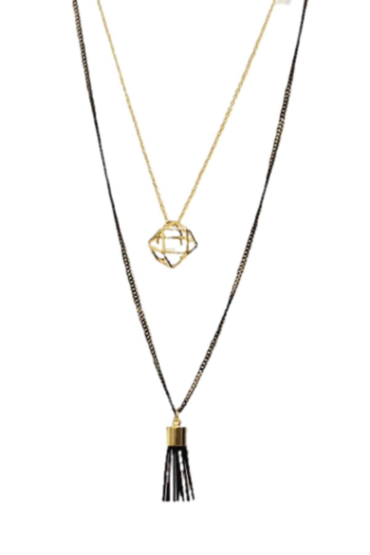 A stylish two-layered Tassel Charm Necklace featuring a polyhedron pendant and a black cord tassel, elegantly displayed against a neutral background.