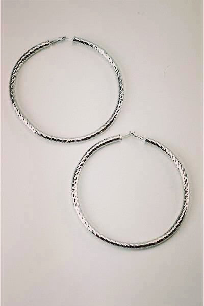 Large textured hoop earrings with omega closure, showcasing a stylish design.