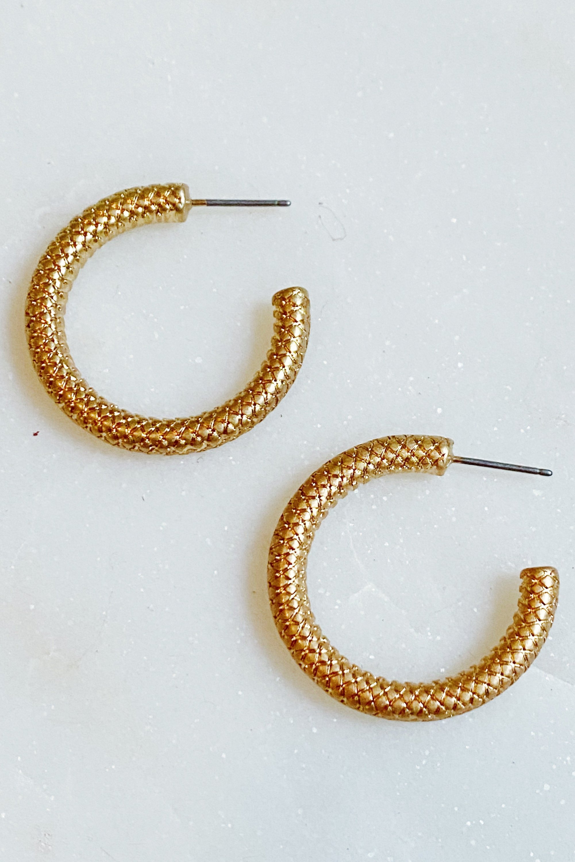 Stylish textured metal open hoop earrings with a 1 inch diameter, showcasing a unique design.