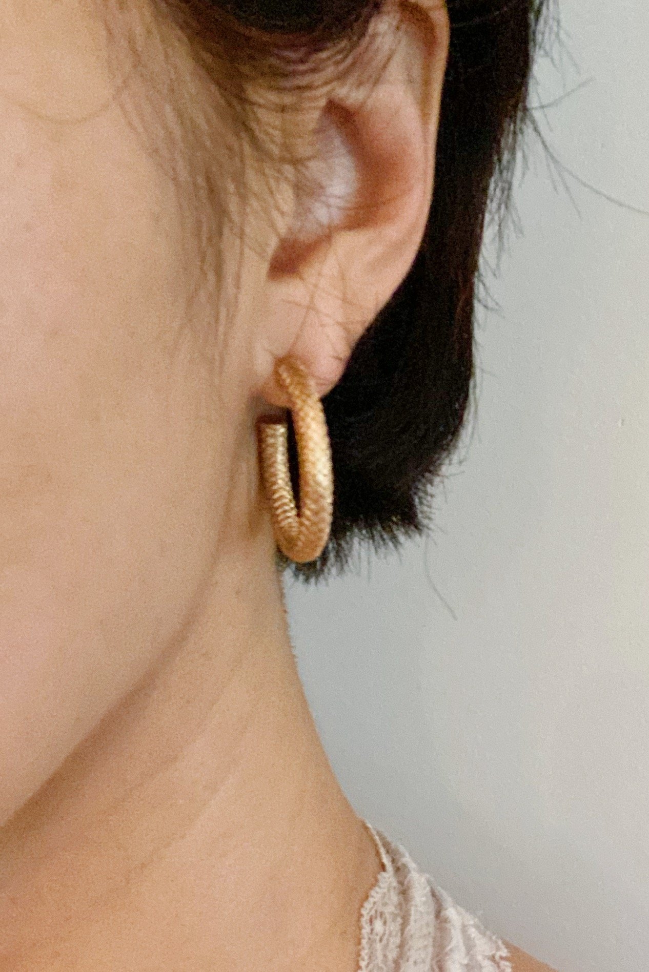 Stylish textured metal open hoop earrings with a 1 inch diameter, showcasing a unique design.