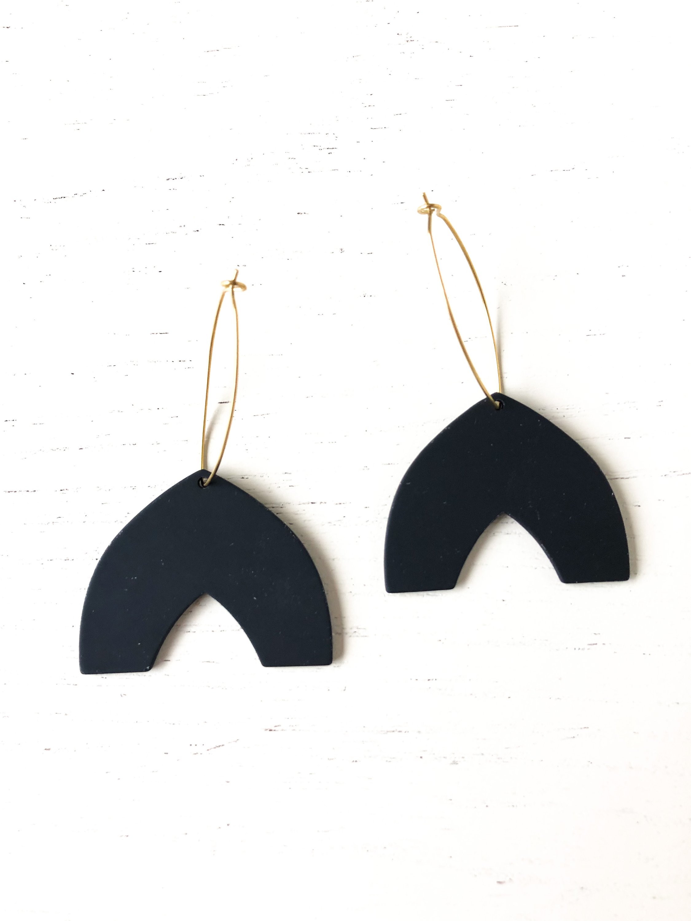 Stylish Arrow earrings featuring black matte resin and nickel-free brass hoops, measuring 2.5 inches in length.