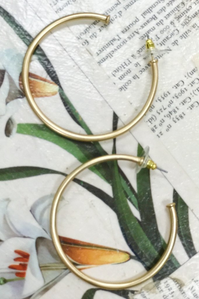 A pair of elegant matte gold hoop earrings with a 2-inch radius, showcasing a modern and stylish design.