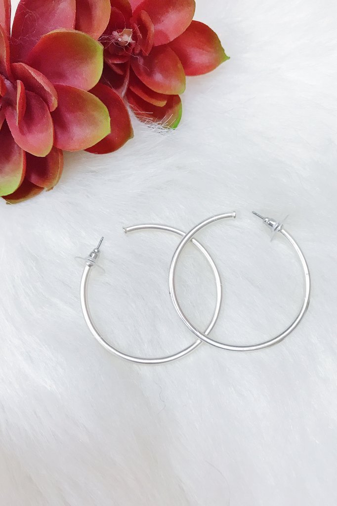 A pair of elegant matte silver hoop earrings with a 2-inch radius, showcasing a stylish and modern design.