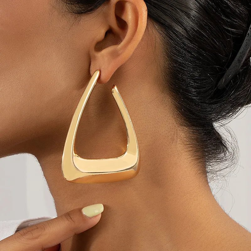 A pair of elegant triangular gold earrings showcasing a modern design, perfect for any occasion.