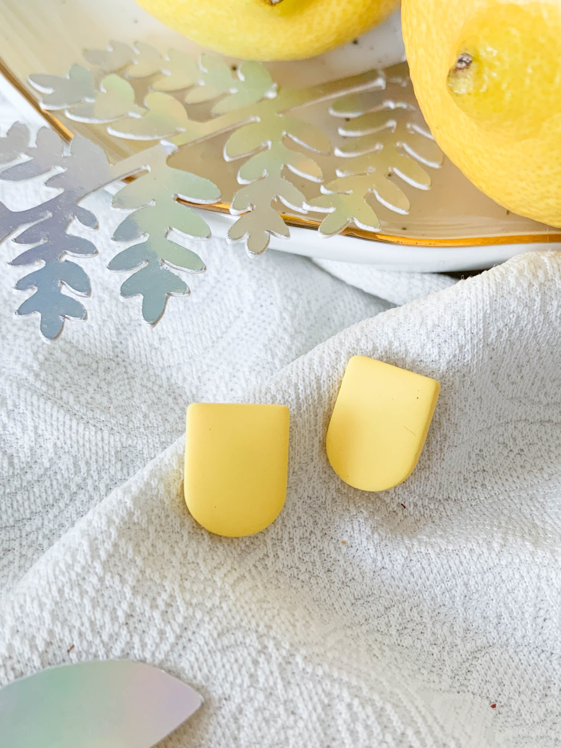 Ulma Lemon earrings featuring a playful lemon design with surgical steel posts for sensitive ears.