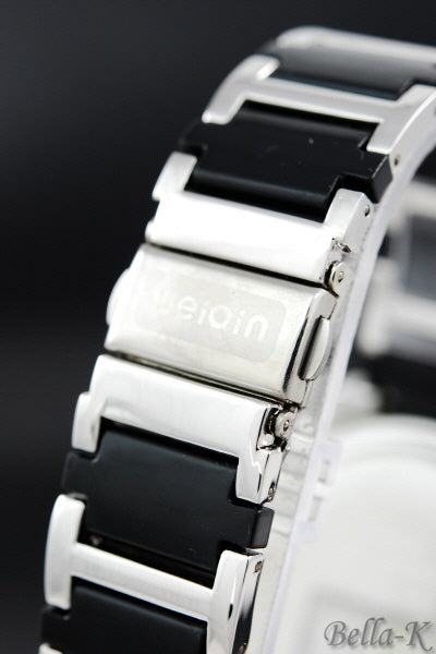 A stylish crystal studded case watch with a stainless steel back and fold over clasp, showcasing its elegant design.