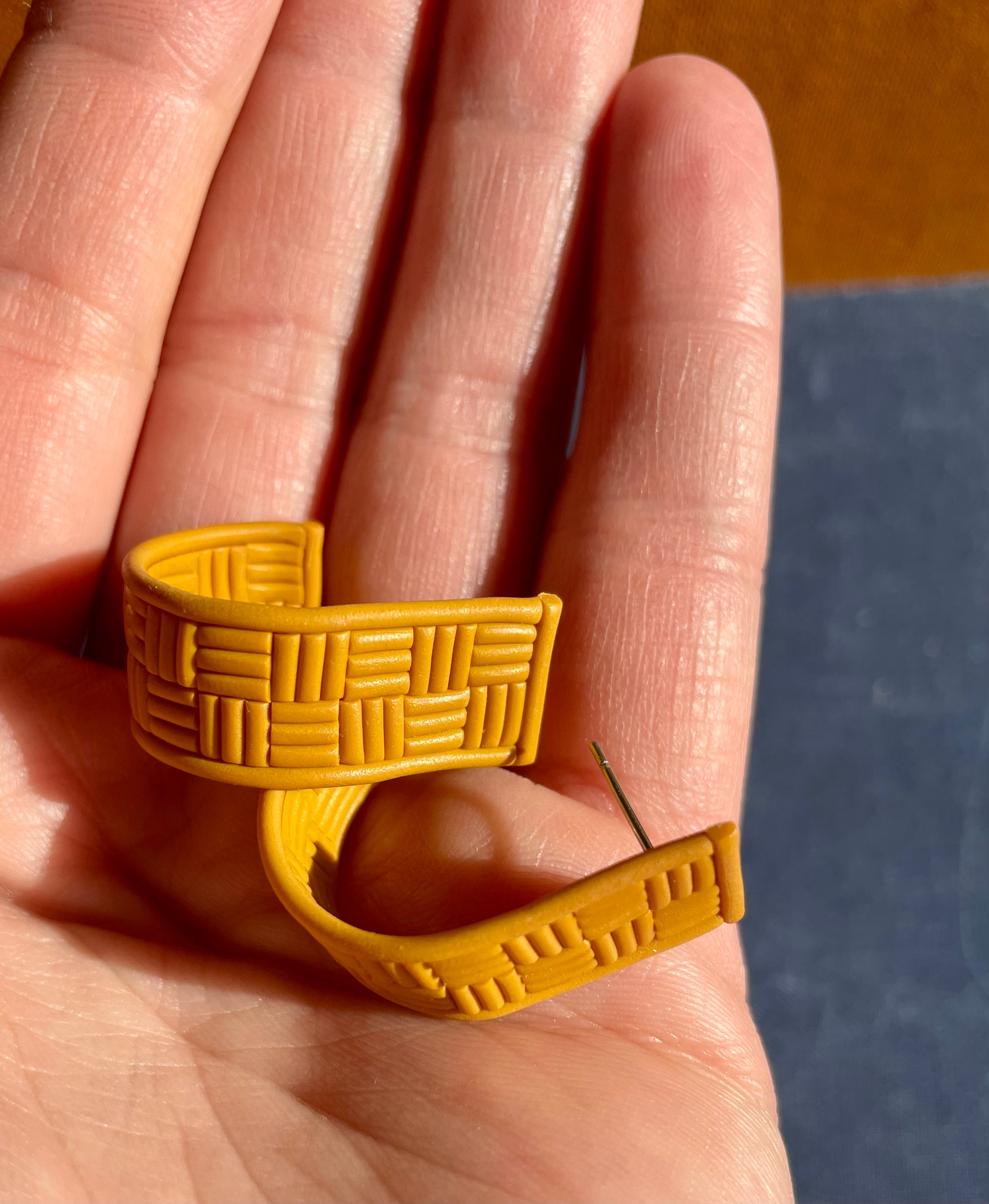 A pair of handmade yellow checked huggie earrings featuring a vibrant check pattern, lightweight design, and stainless steel hooks.