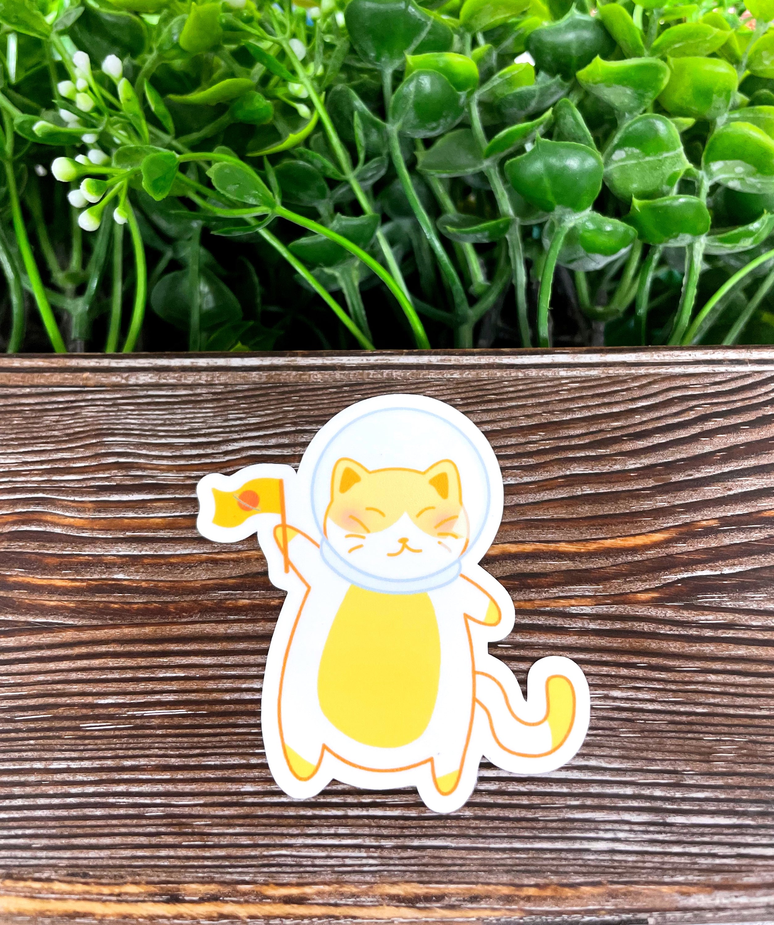 A vibrant Astronaut Cat Sticker featuring a playful cat in a space suit, perfect for personalizing various smooth surfaces.