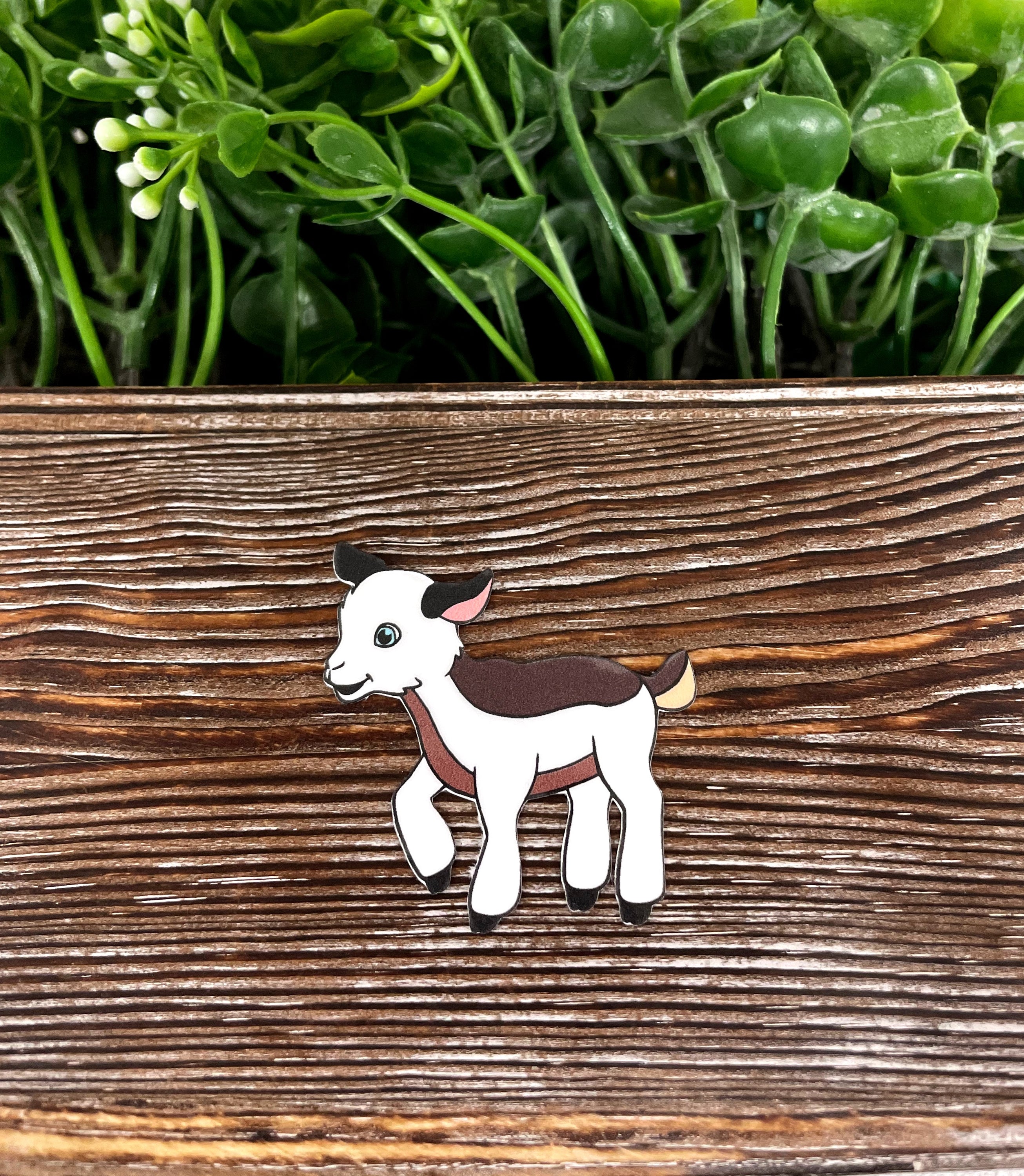 A colorful die cut vinyl sticker featuring a playful baby goat, perfect for personalizing items with a boho style.