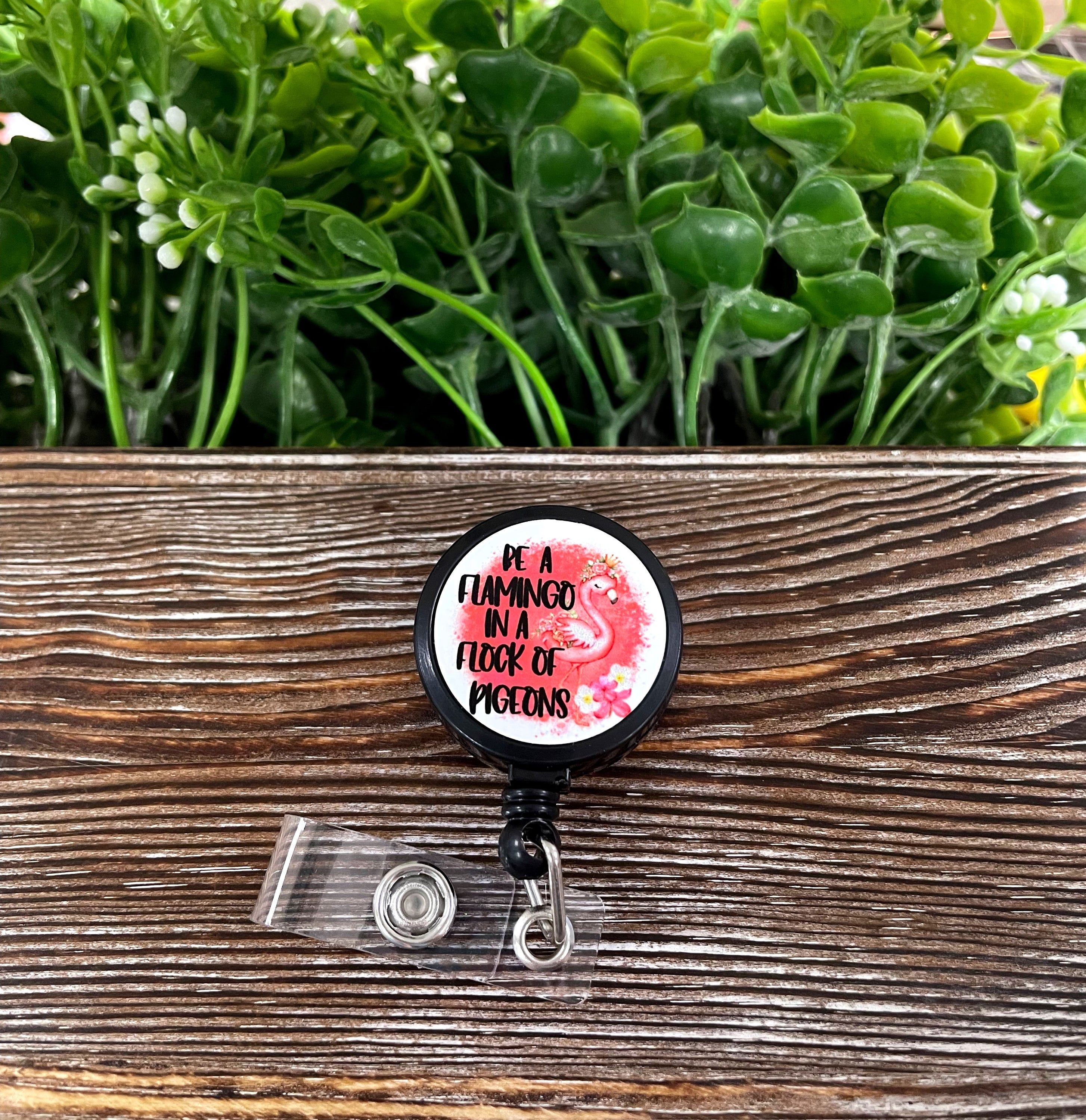 A colorful retractable badge reel featuring a flamingo design, showcasing its vibrant colors and quality metal finish.