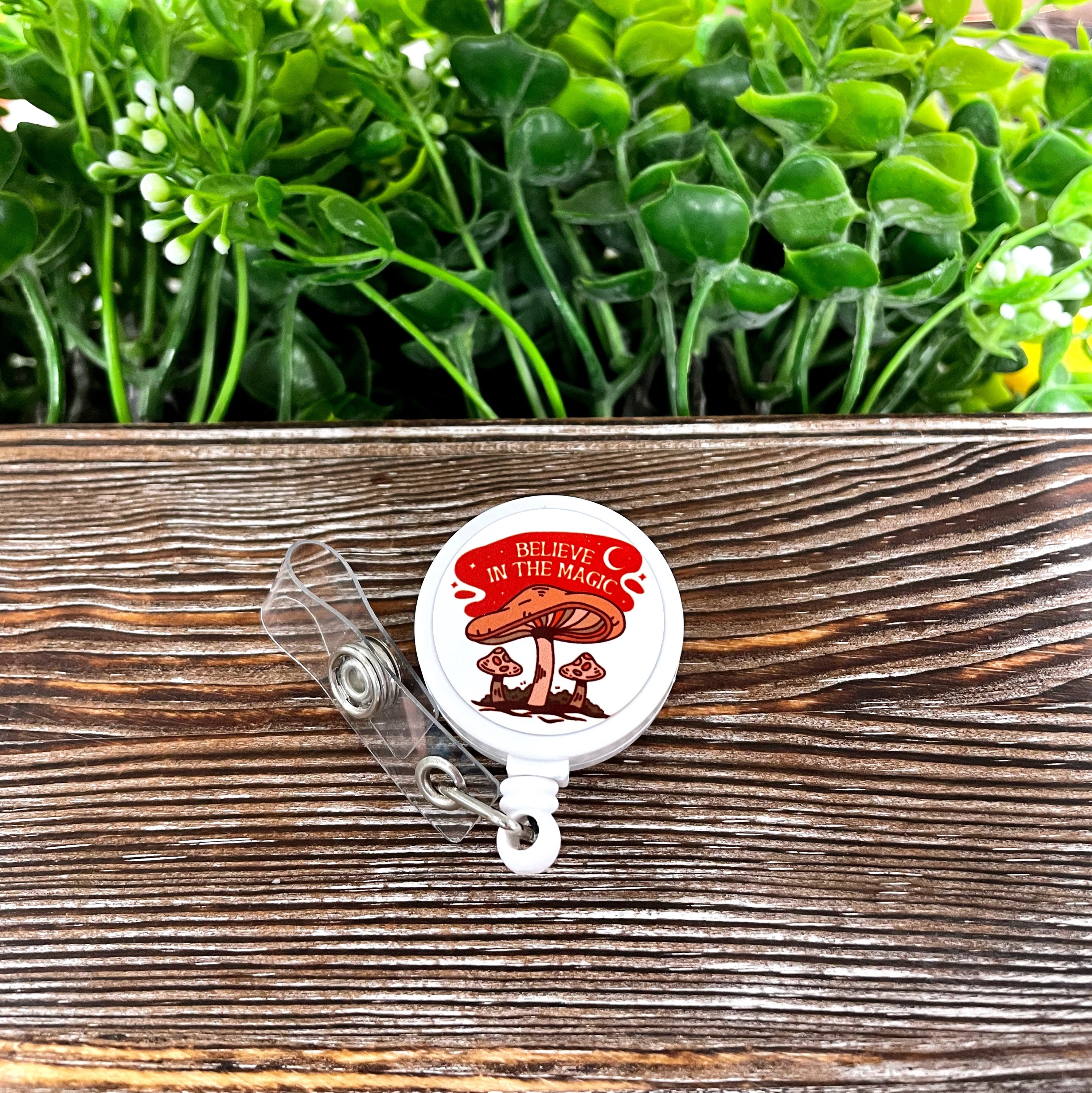 Retractable badge reel featuring a colorful boho mushroom design on a metal blank, attached to a durable plastic reel.