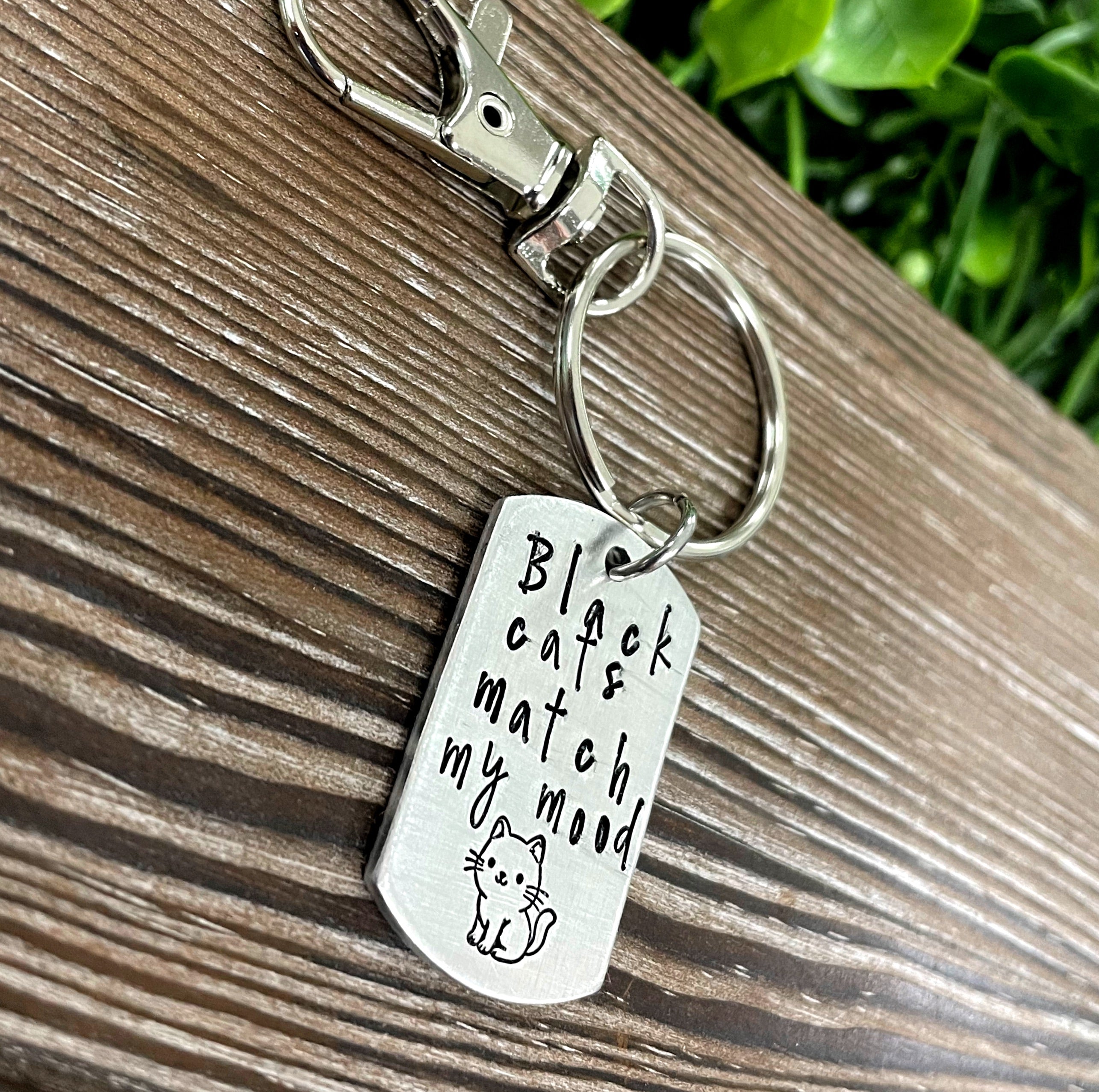 Hand-stamped key chain featuring the phrase 'Black cats Match my mood' with a fun animal theme, showcasing unique craftsmanship.