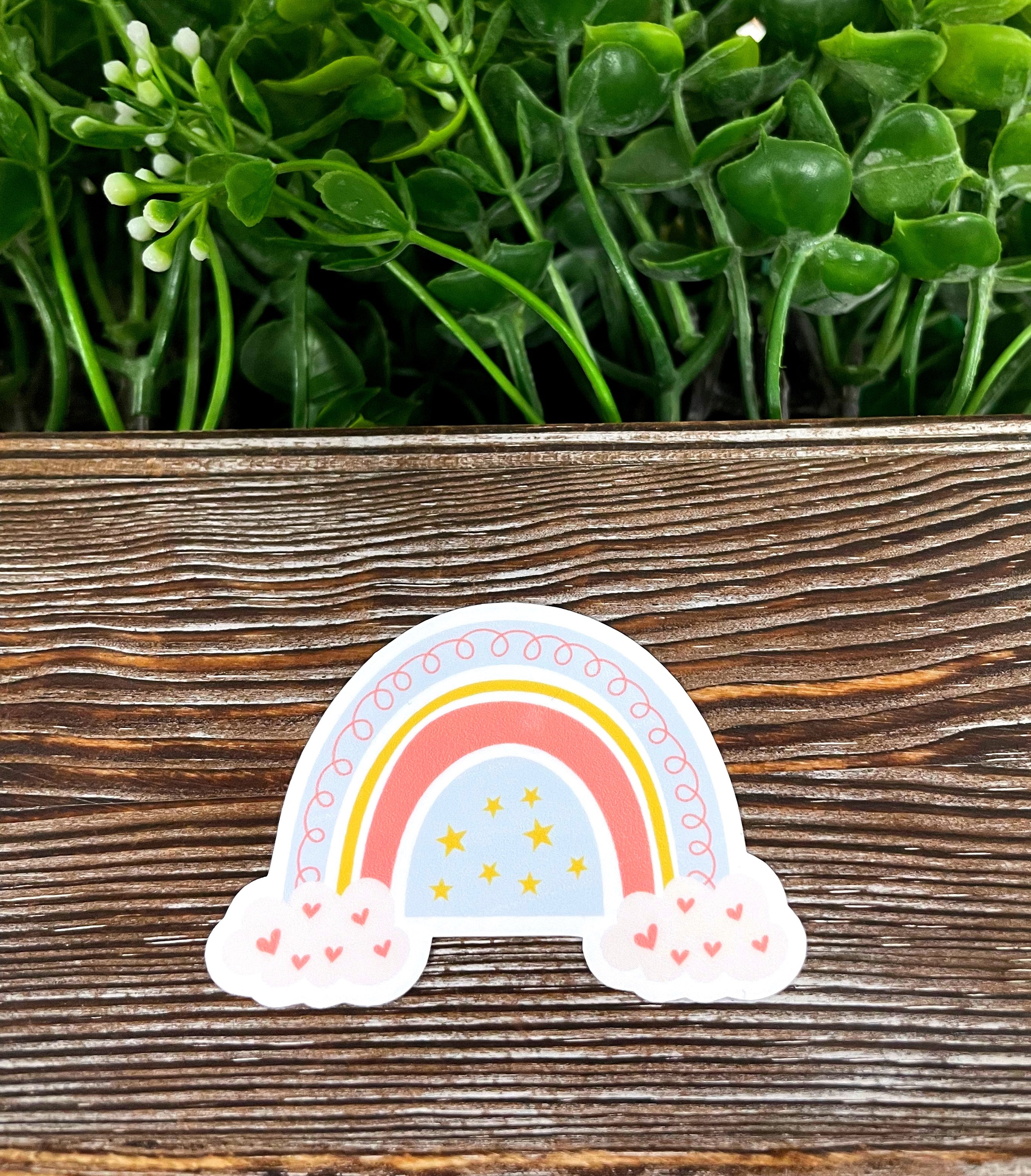 Colorful Bohemian Rainbow Clouds die cut sticker on a smooth surface, showcasing vibrant colors and intricate design.