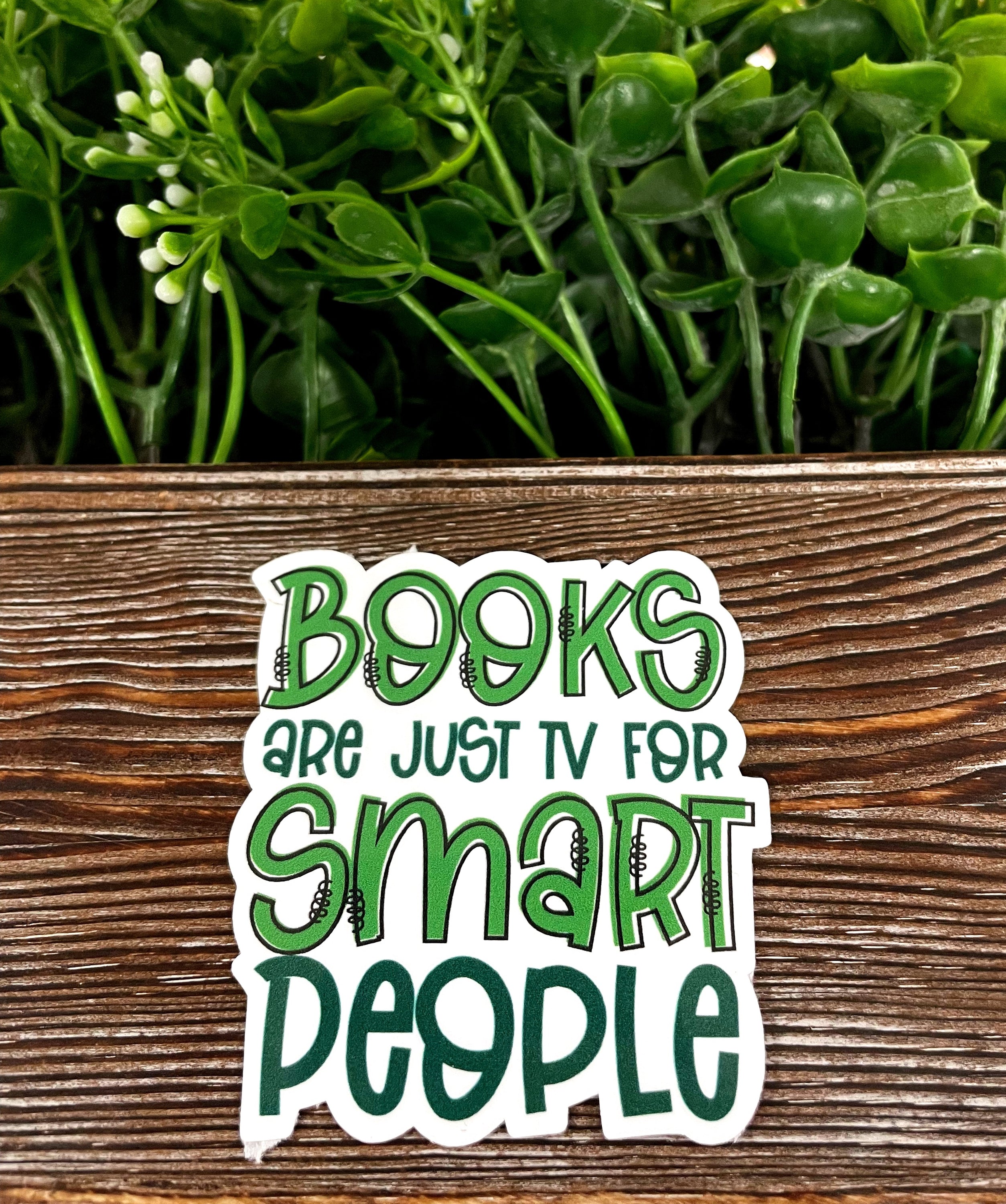 A vibrant die cut sticker featuring the phrase 'Books are just TV for Smart People', showcasing a unique graphic art design on a smooth surface.