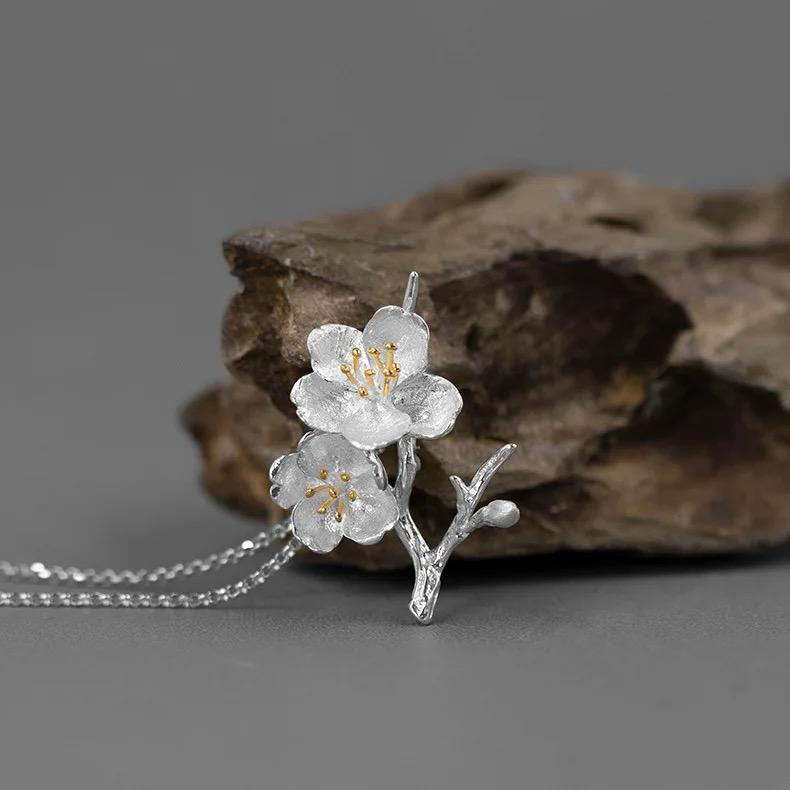 A beautiful Cherry Blossoms Necklace featuring three intricately designed cherry blossom flowers in 925 sterling silver with 18k gold plating.