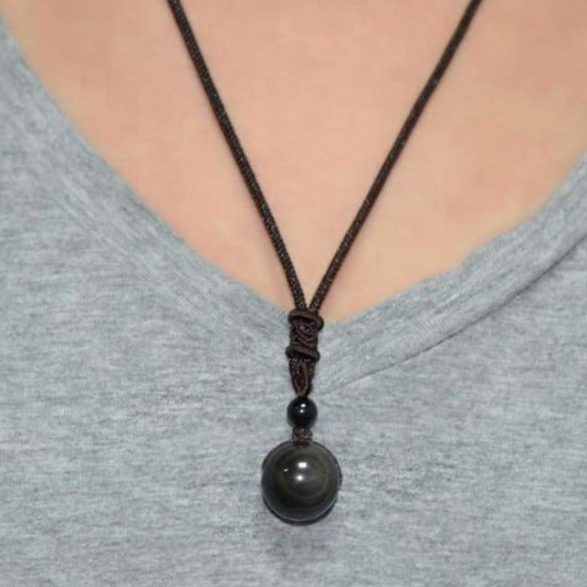 Collier Oeil Céleste en obsidienne arc-en-ciel, mettant en valeur ses couleurs uniques et son design élégant.