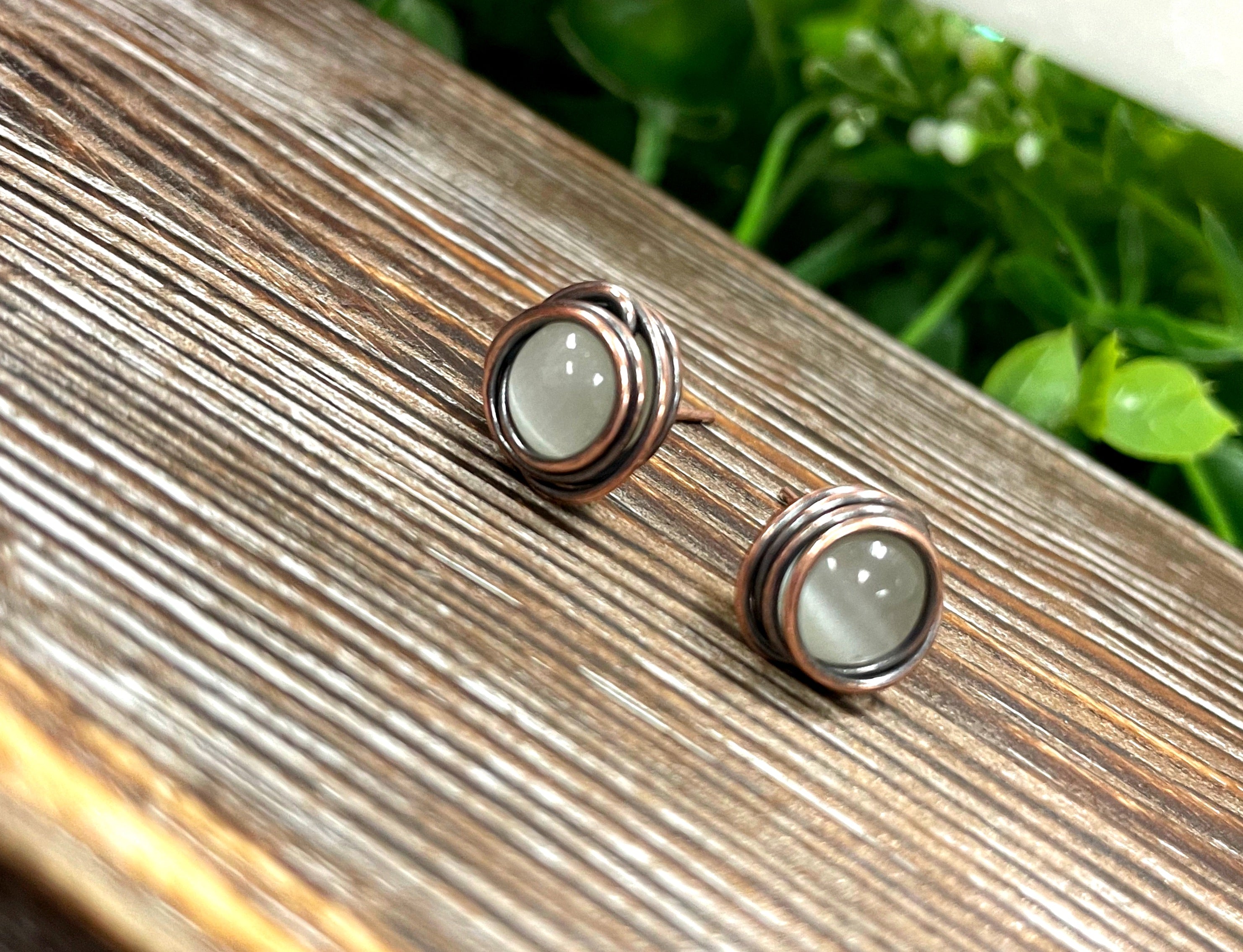 Handmade copper stud earrings featuring 8 mm cat eye beads, showcasing a unique and elegant design.