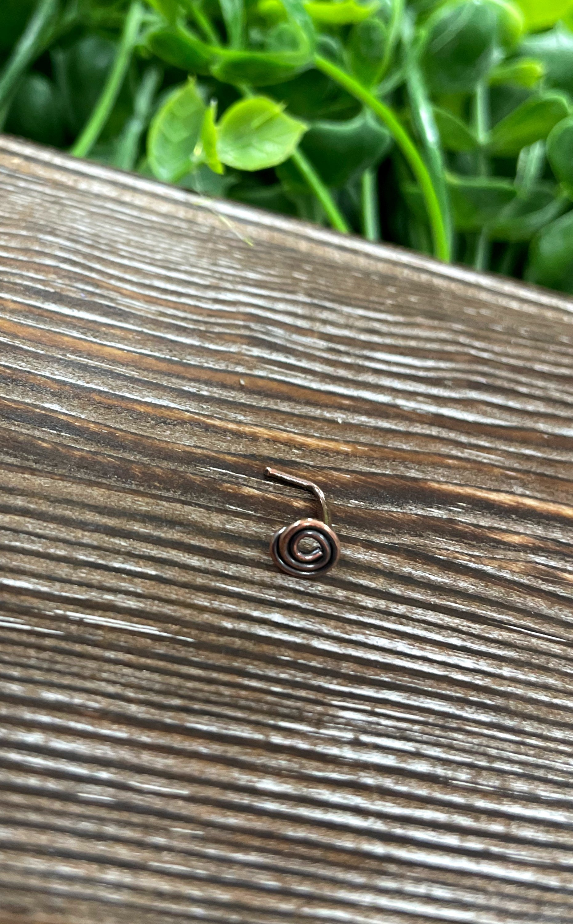 Handcrafted copper swirl minimalist L shape nose ring with oxidized finish, showcasing its unique design and craftsmanship.