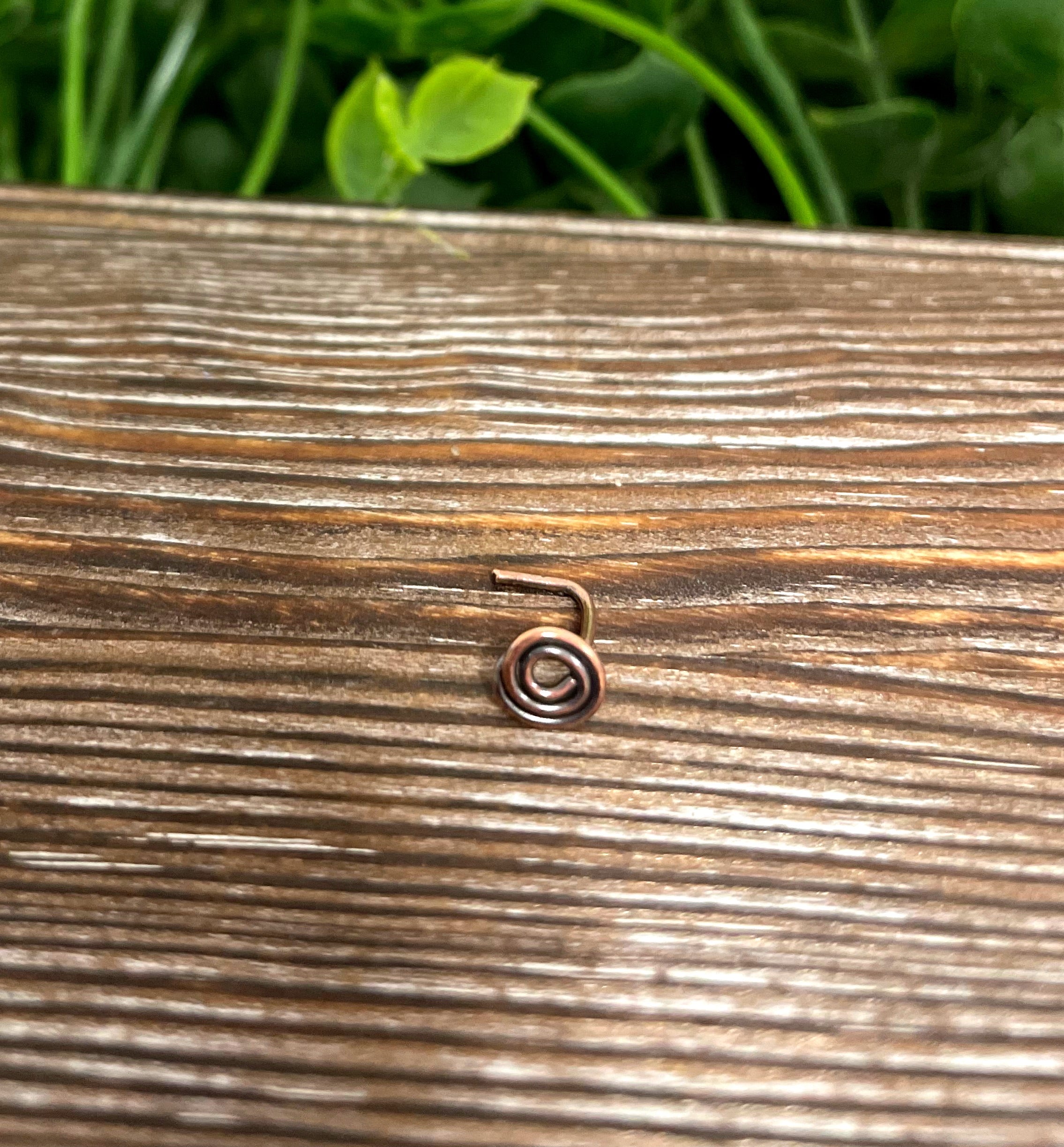 Handcrafted copper swirl minimalist L shape nose ring with oxidized finish, showcasing its unique design and craftsmanship.