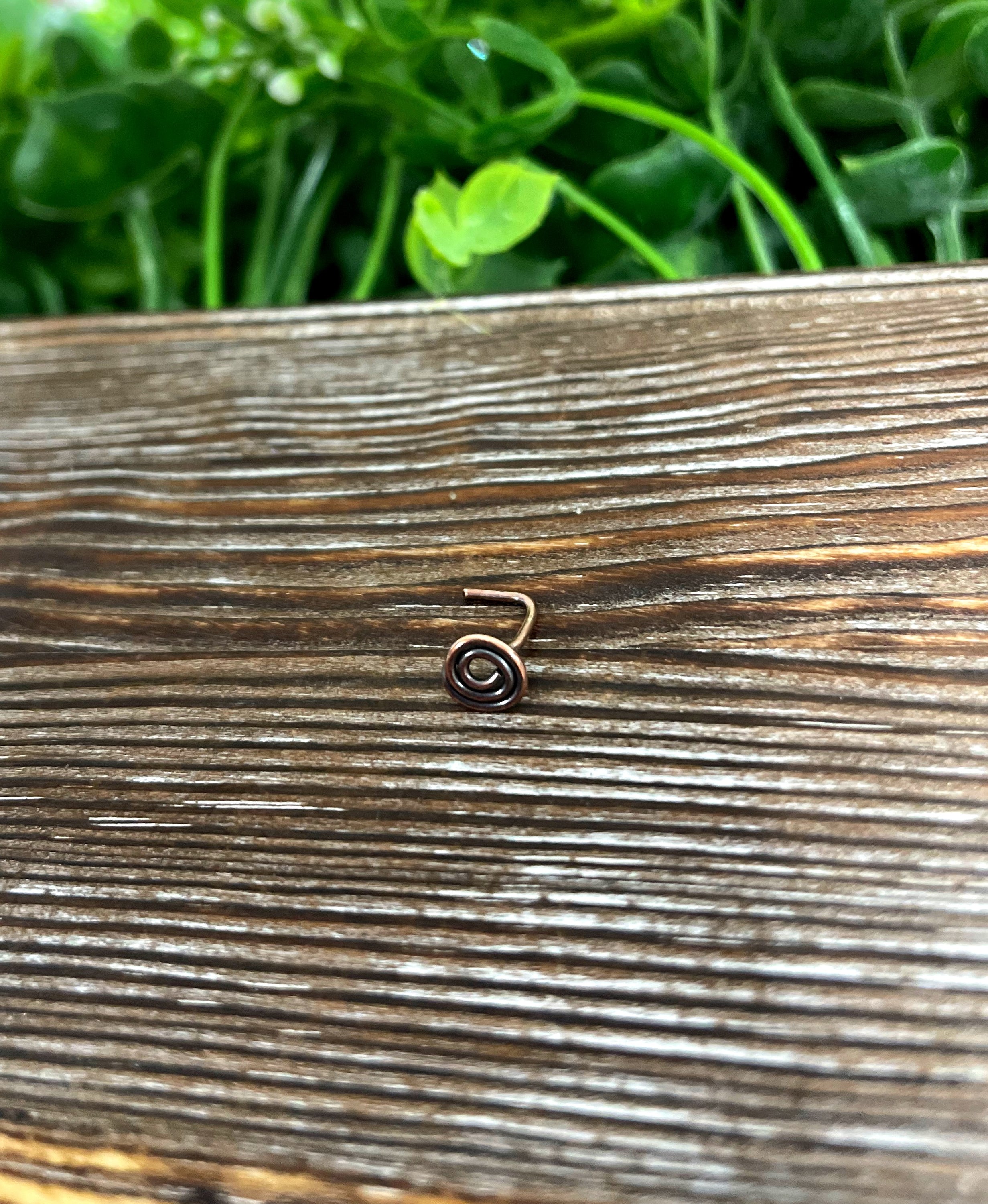 Handcrafted copper swirl minimalist L shape nose ring with oxidized finish, showcasing its unique design and craftsmanship.