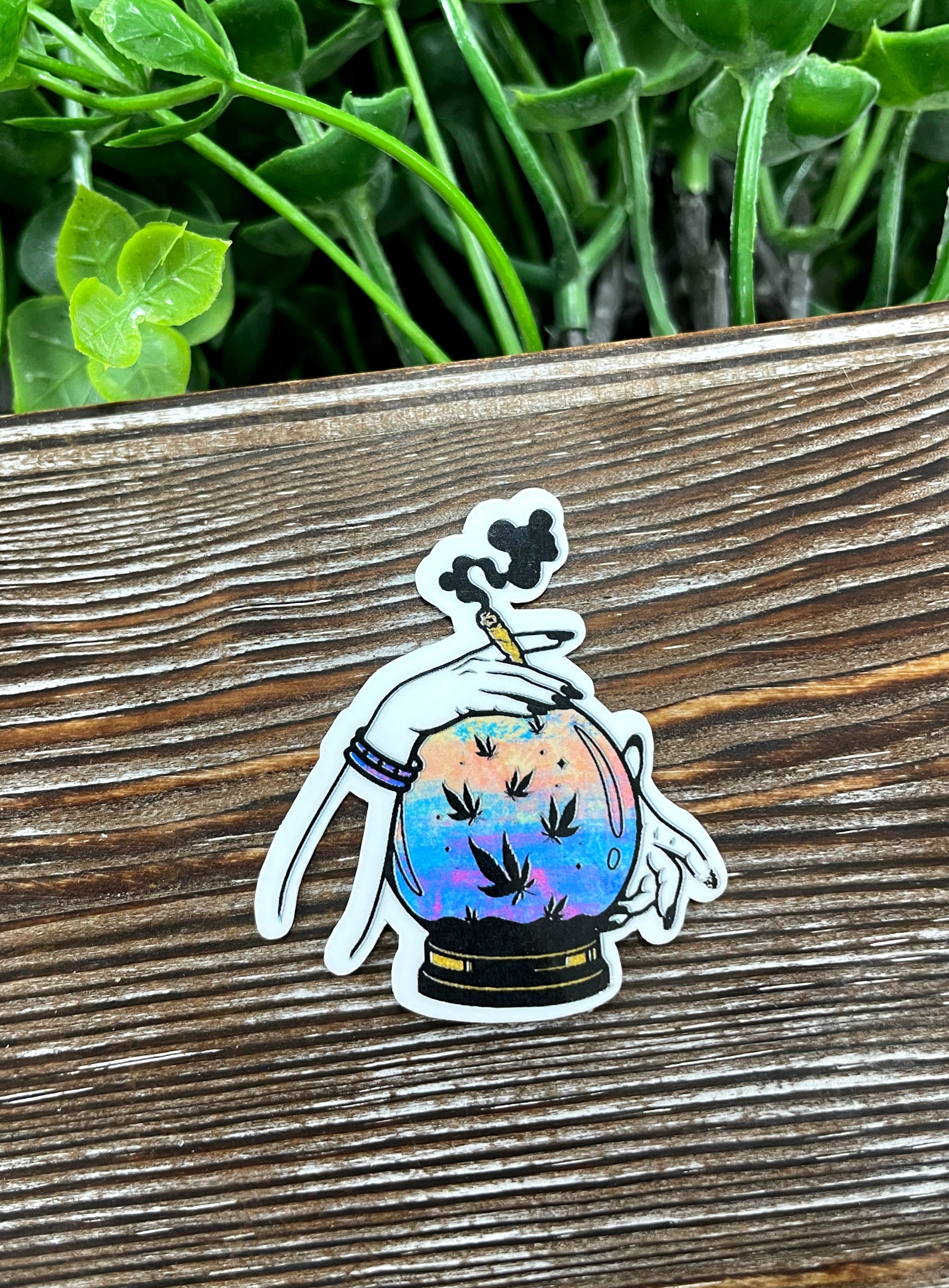 A vibrant Crystal Ball Sticker featuring graphic art, perfect for weed smokers, displayed on a smooth surface.