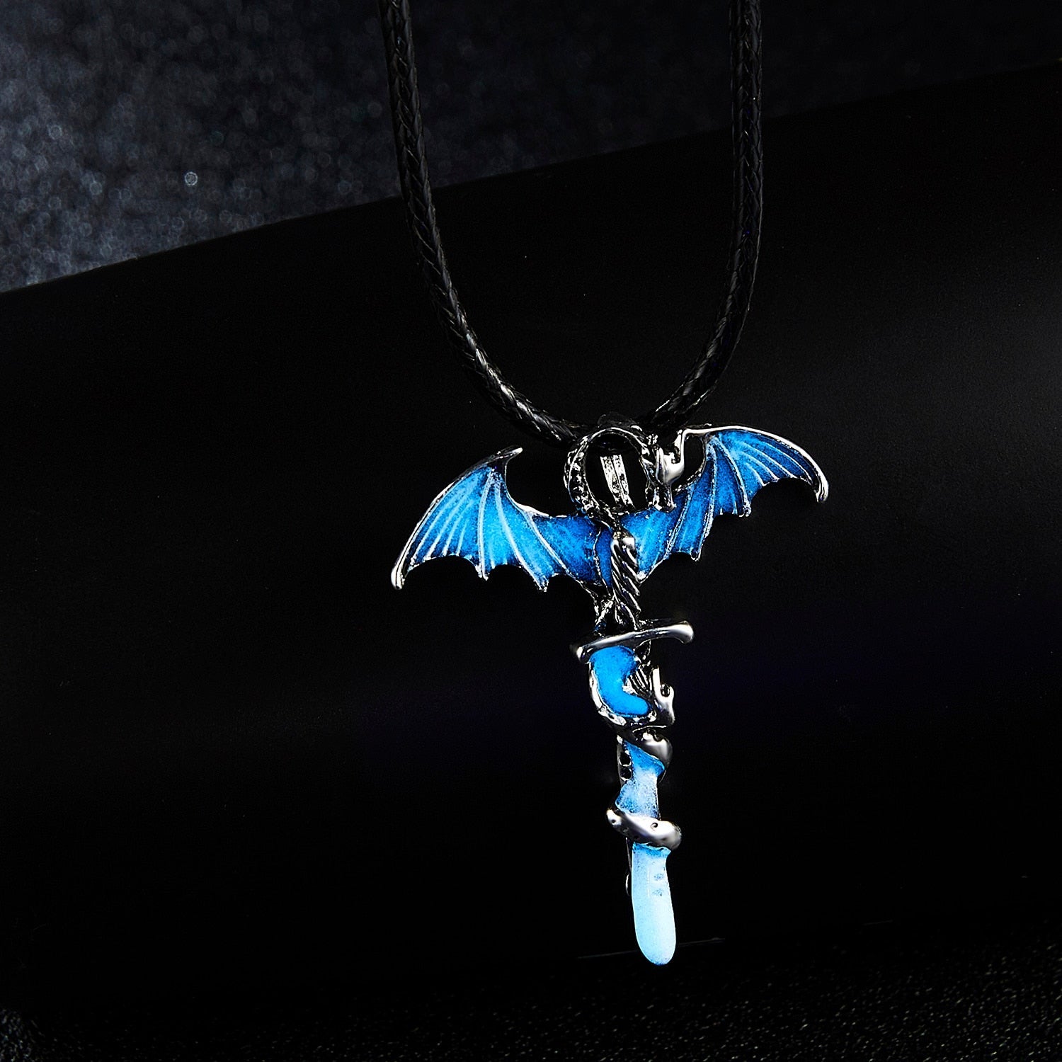 A glowing dragon pendant on a rope necklace, showcasing intricate details in blue, blue-green, and yellow-green colors.