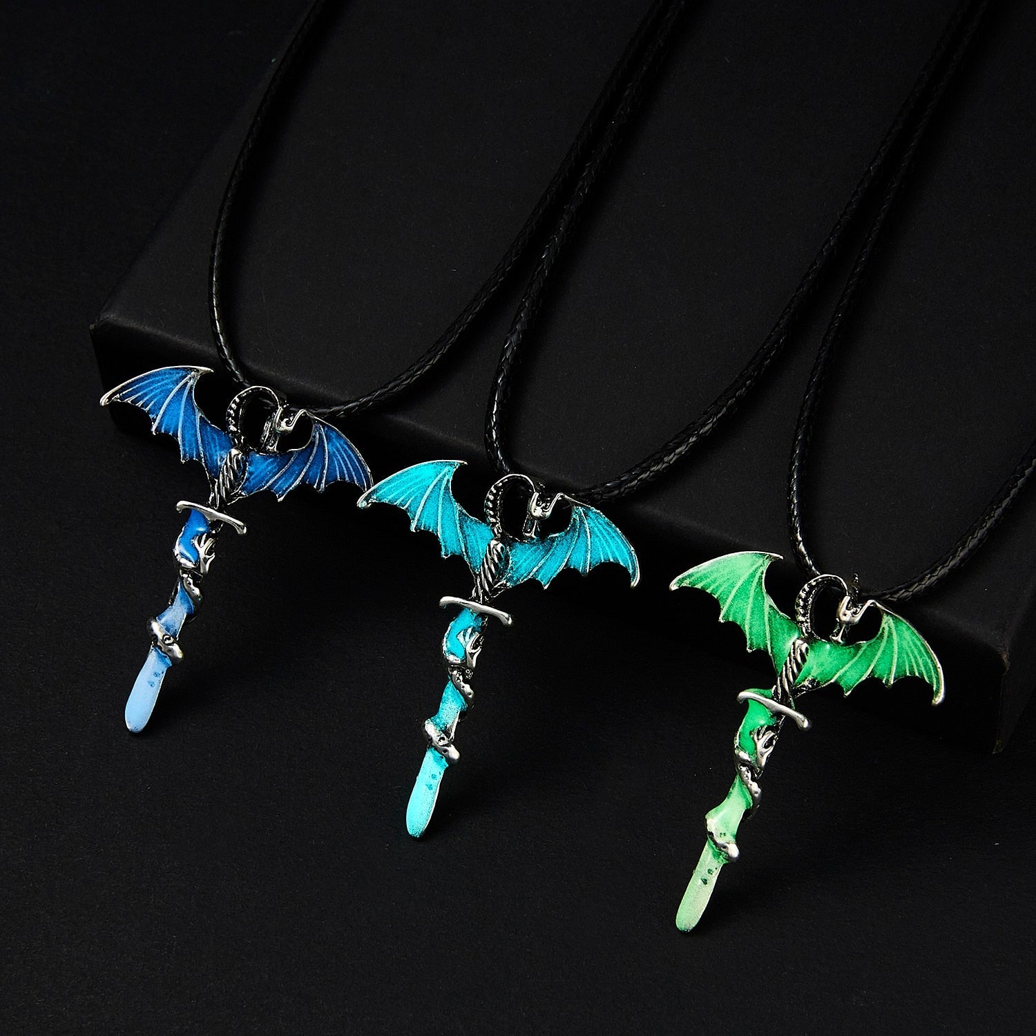 A glowing dragon pendant on a rope necklace, showcasing intricate details in blue, blue-green, and yellow-green colors.