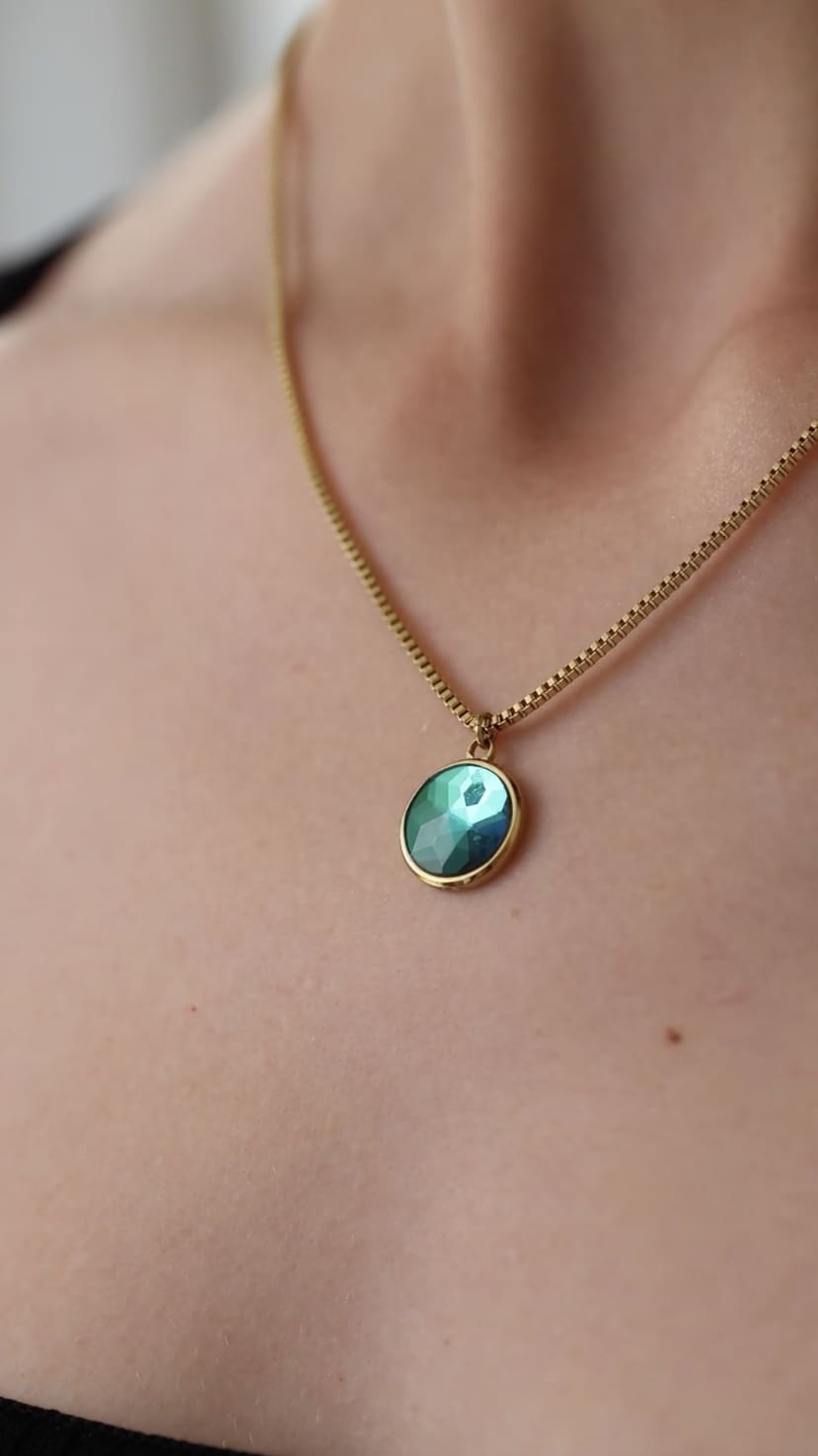 Facet Pendant Necklace JS.0007 featuring a green and gold pendant on a stainless steel chain, elegantly displayed against a neutral background.