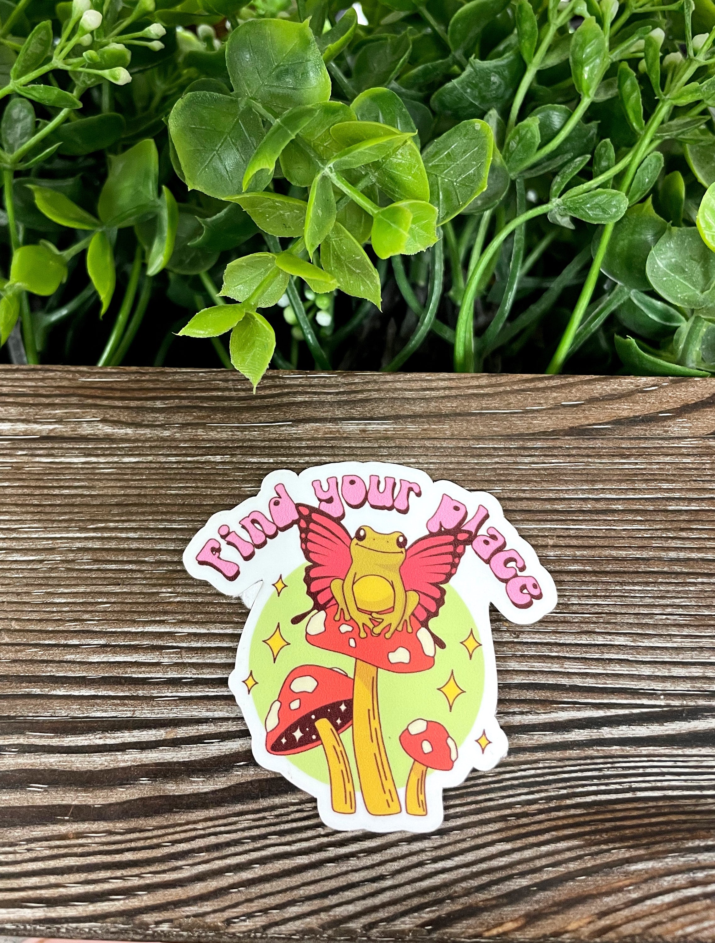 Die cut vinyl sticker featuring a frog sitting on a colorful mushroom, perfect for personalizing smooth surfaces.