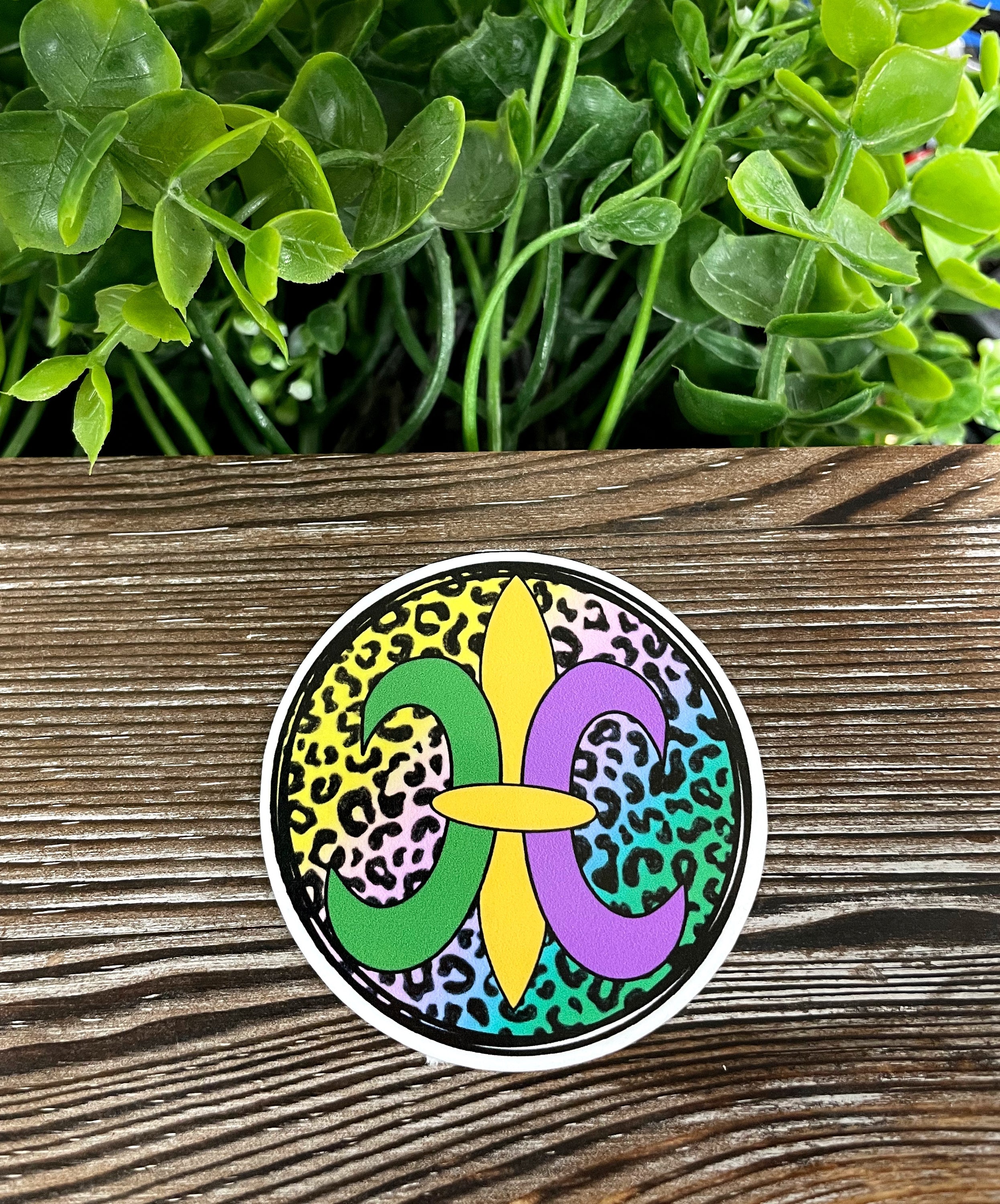 Fleur De Lis die cut vinyl sticker on a smooth surface, showcasing vibrant colors and intricate design.