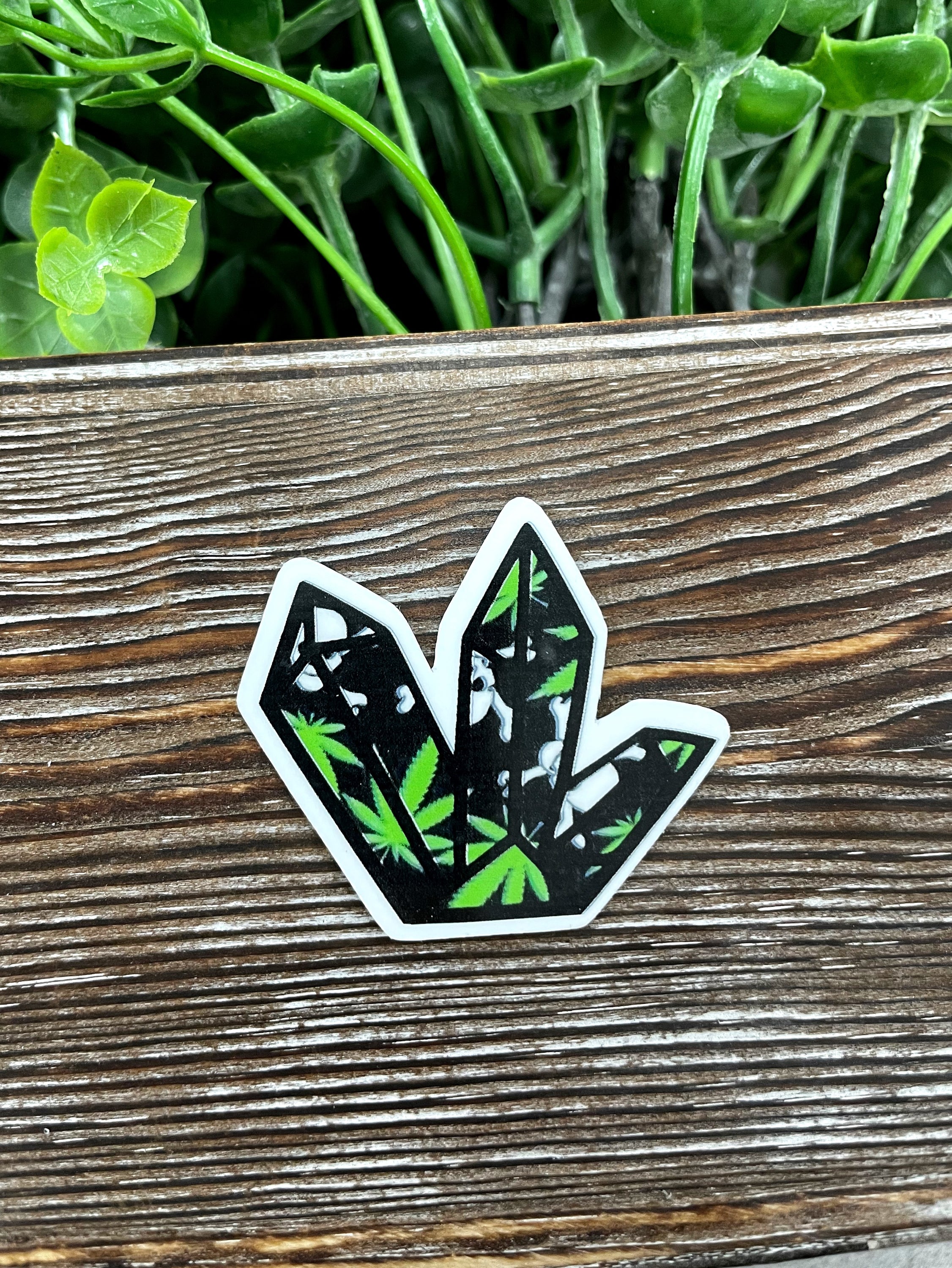 Green and black crystal die cut sticker on a smooth surface, showcasing vibrant colors and intricate design.