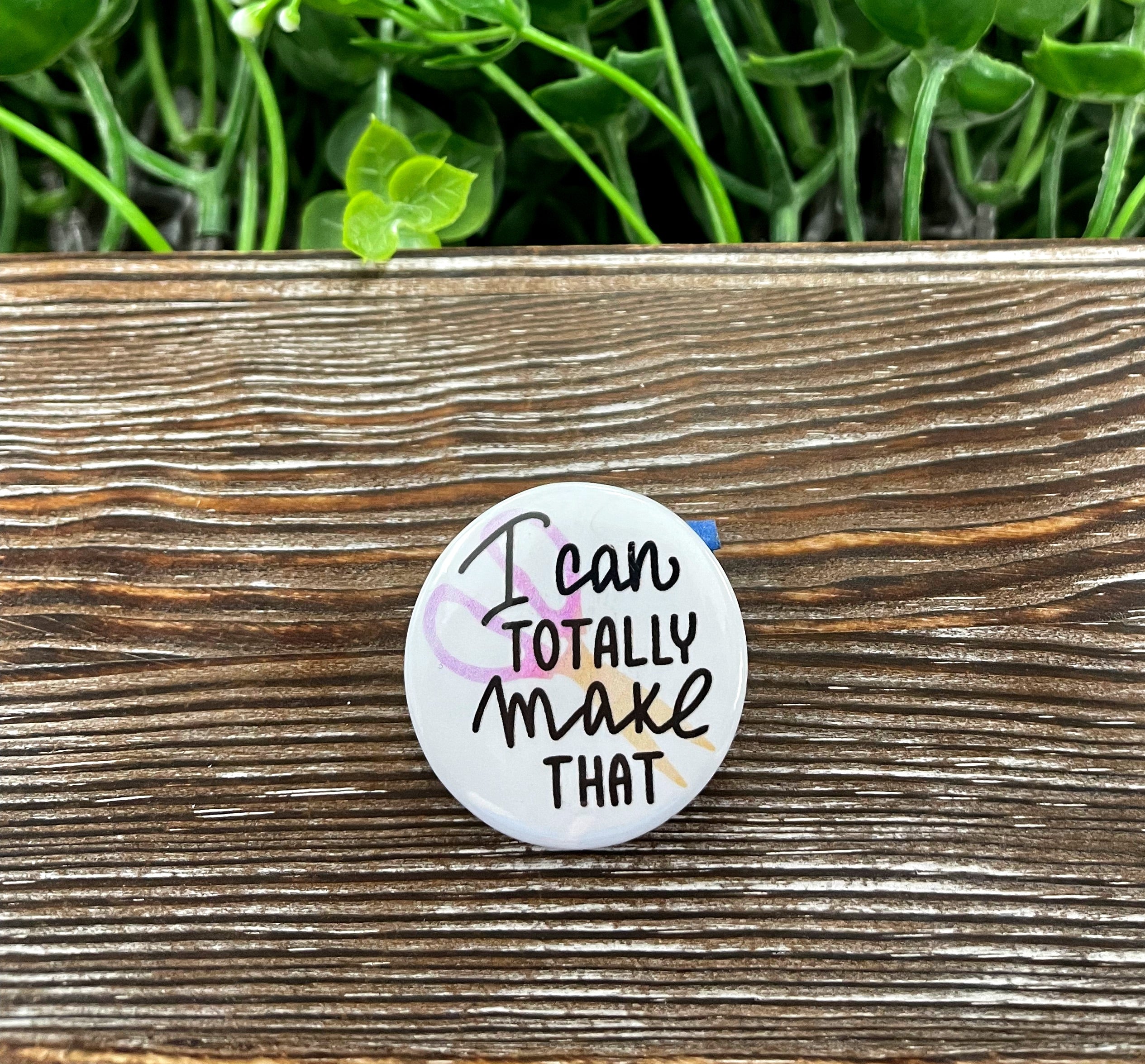 A vibrant 1.25-inch graphic art button featuring the phrase 'I Can Totally Make That', perfect for personalizing bags and accessories.