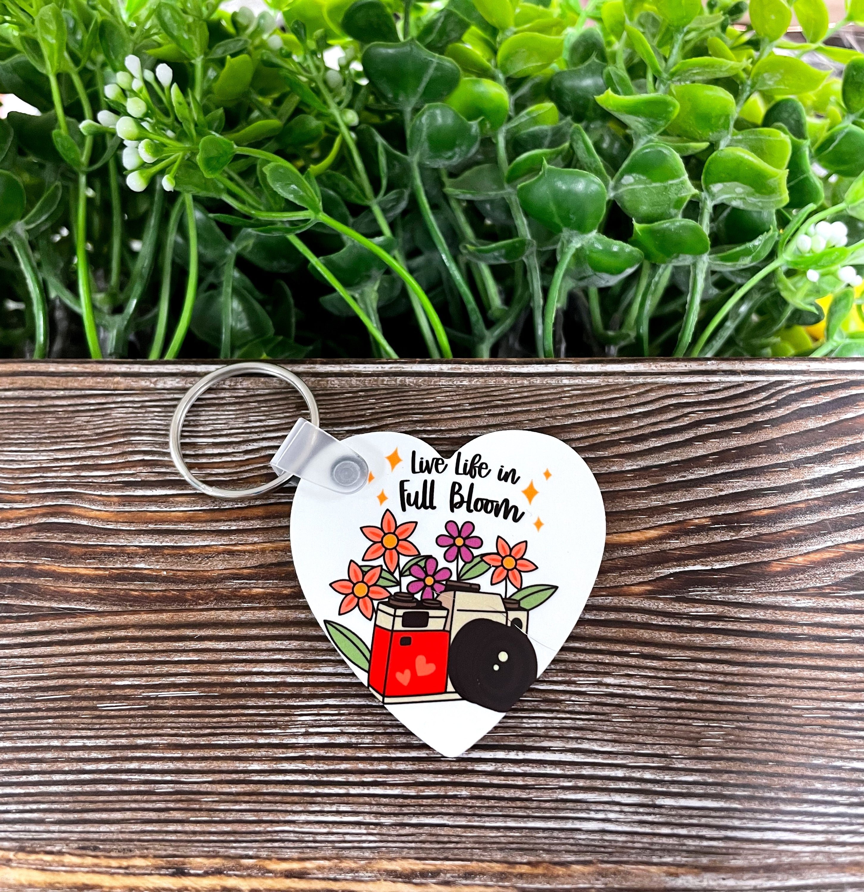 A vibrant MDF heart keychain featuring the phrase 'Live Life in Full Bloom', showcasing a boho design with colorful patterns.