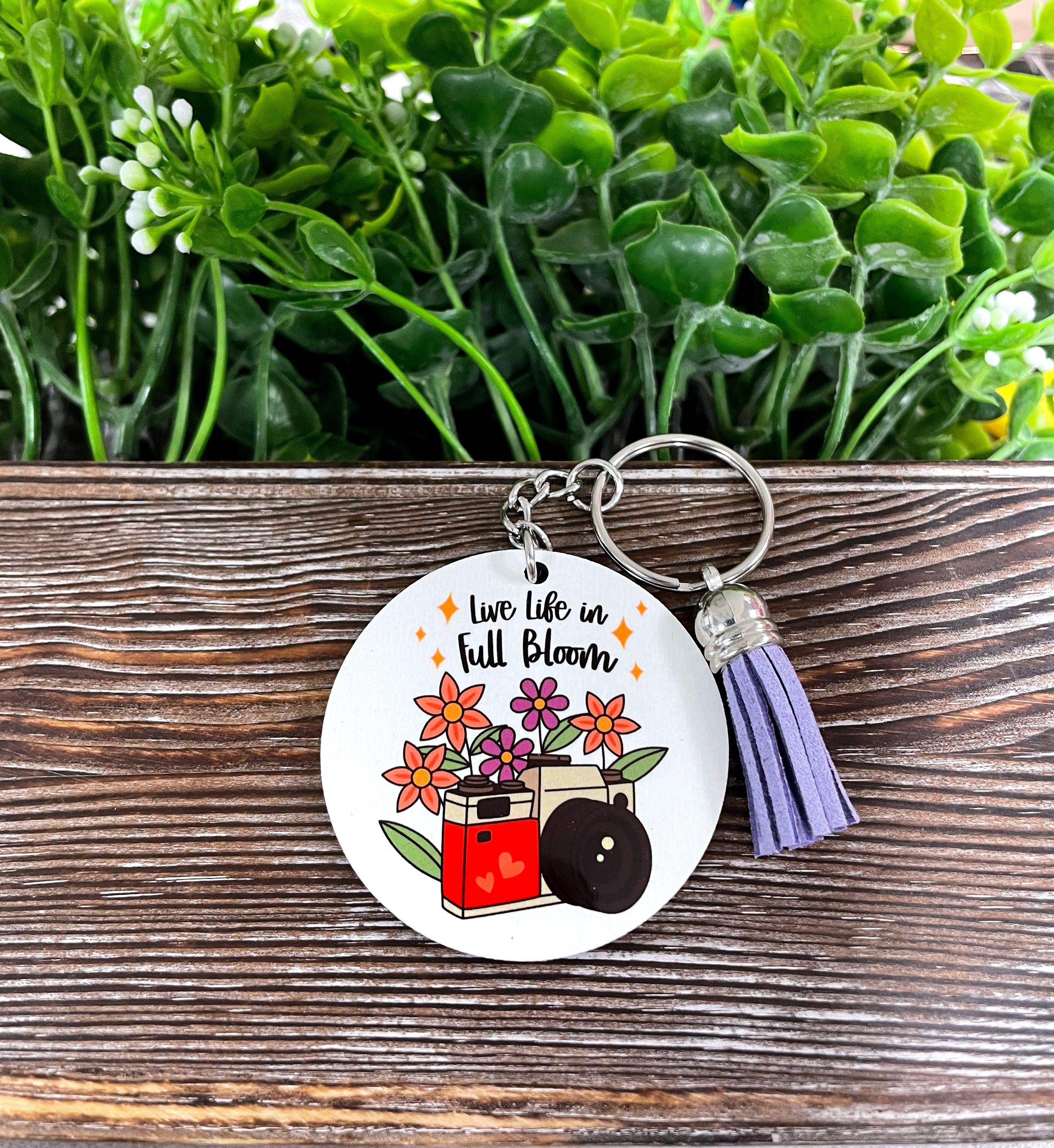 A colorful MDF round keychain featuring the phrase 'Live Life in Full Bloom', showcasing a boho design with vibrant colors.