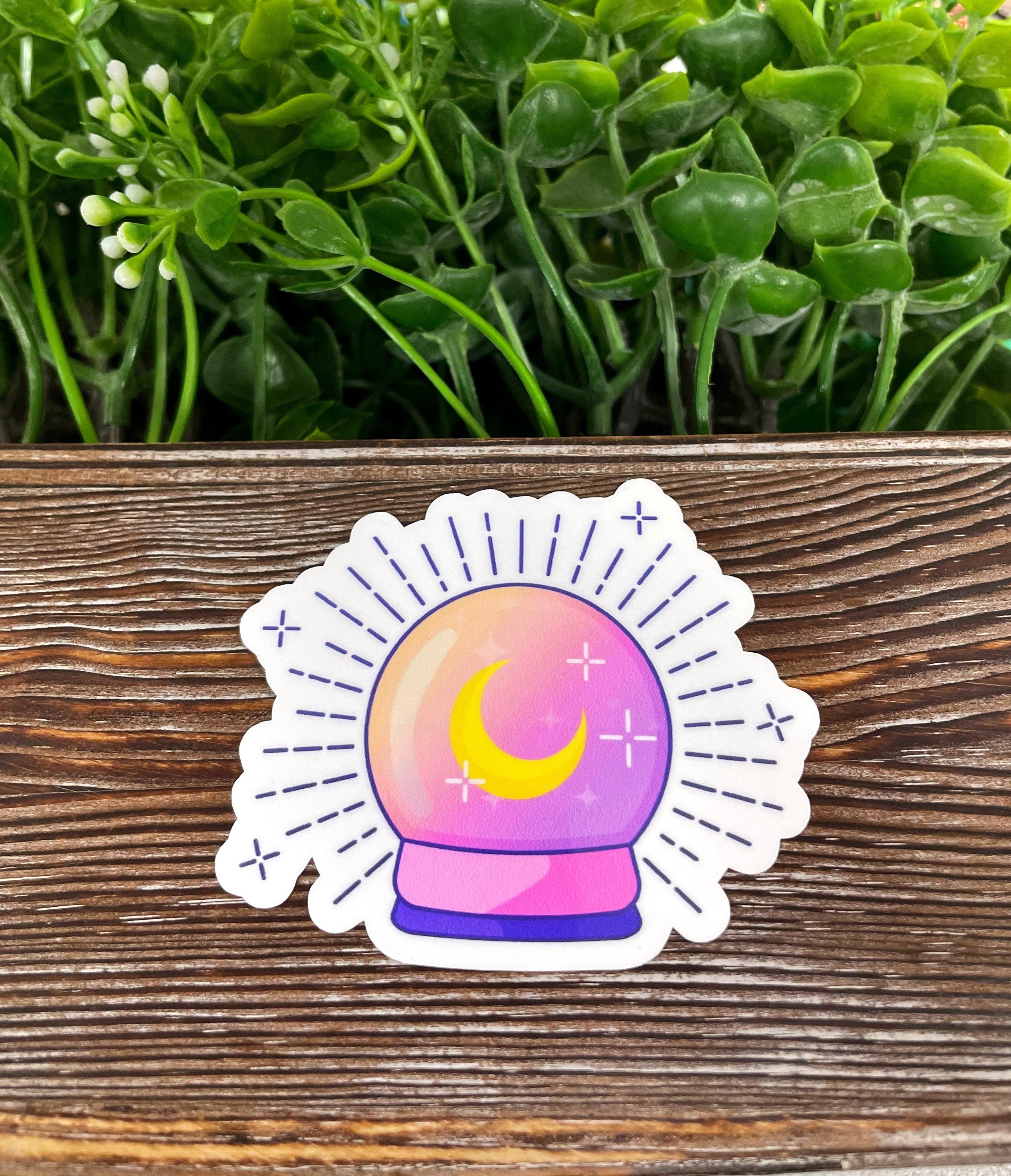 Magical Purple Crystal Ball die cut vinyl sticker on a smooth surface, showcasing vibrant colors and intricate design.