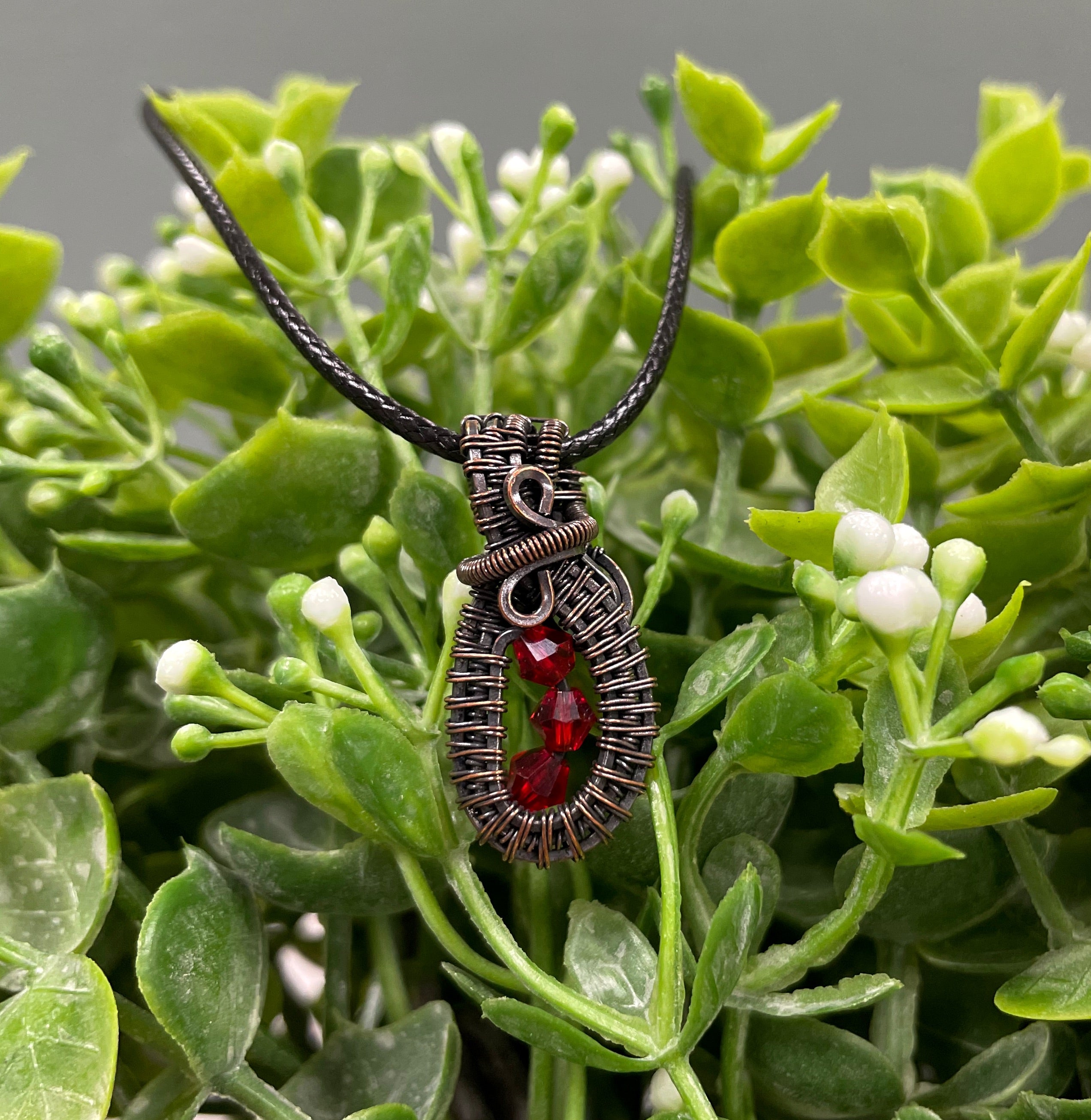 Mini wire wrapped pendant featuring three red glass crystals elegantly wrapped in argentium sterling silver wire on a 24-inch snake chain.