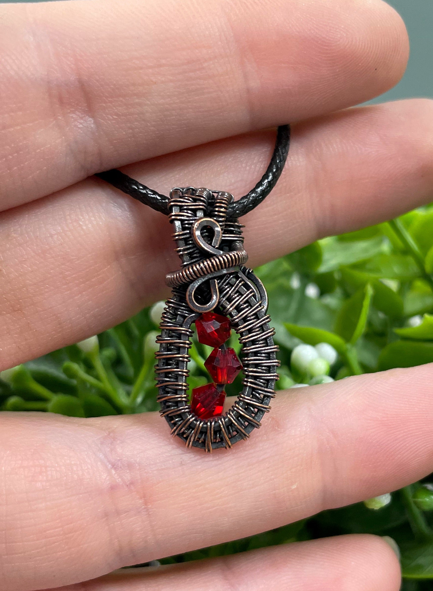 Mini wire wrapped pendant featuring three red glass crystals elegantly wrapped in argentium sterling silver wire on a 24-inch snake chain.