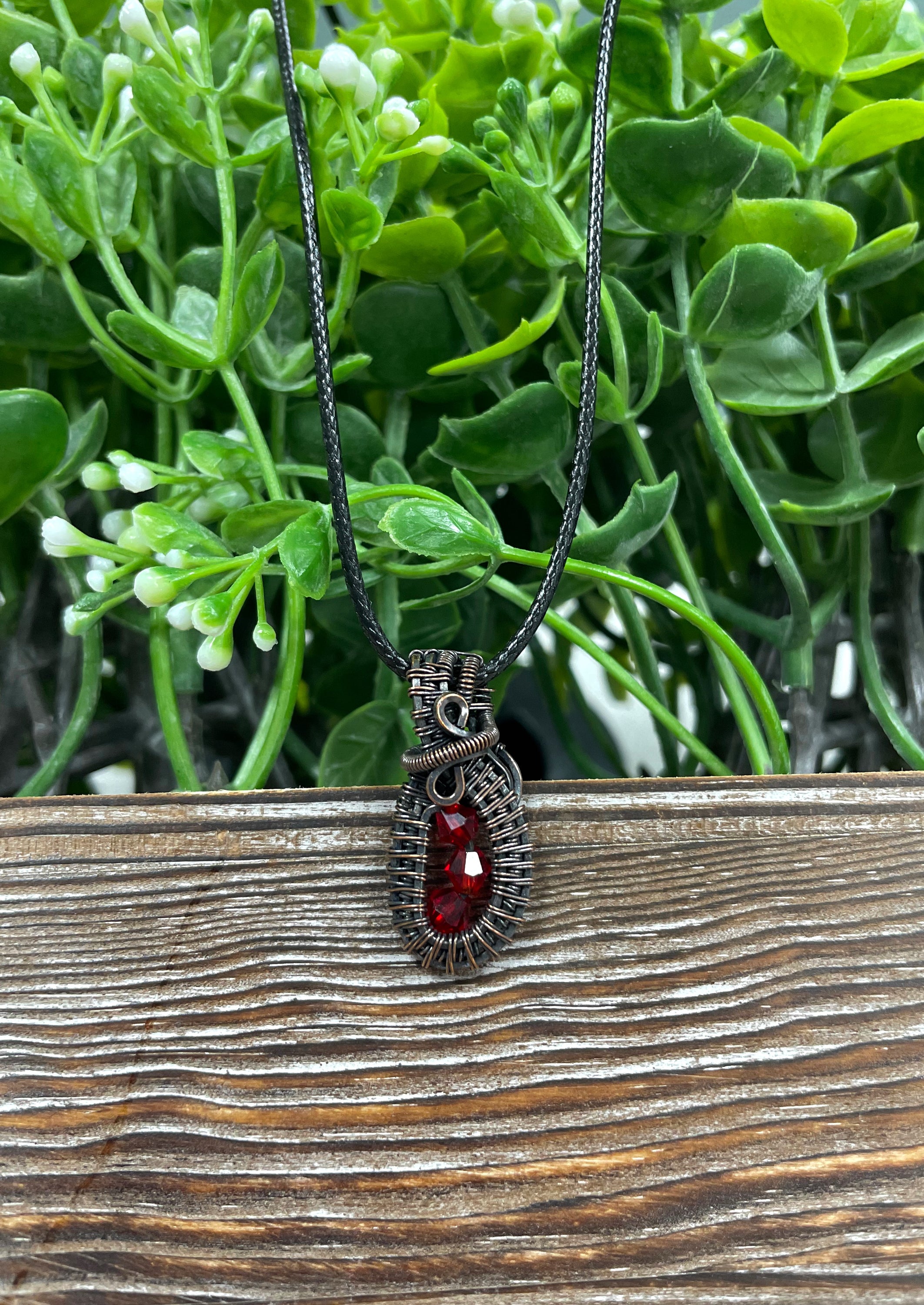 Mini wire wrapped pendant featuring three red glass crystals elegantly wrapped in argentium sterling silver wire on a 24-inch snake chain.